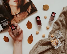 Nail polish bottles with autumn leaves and magazine.