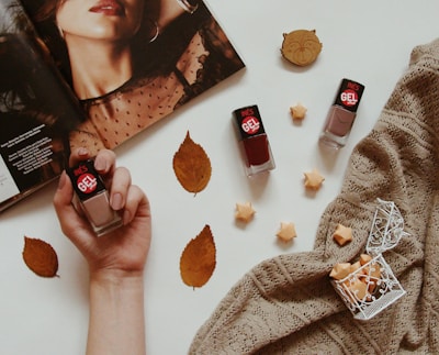Nail polish bottles with autumn leaves and magazine.