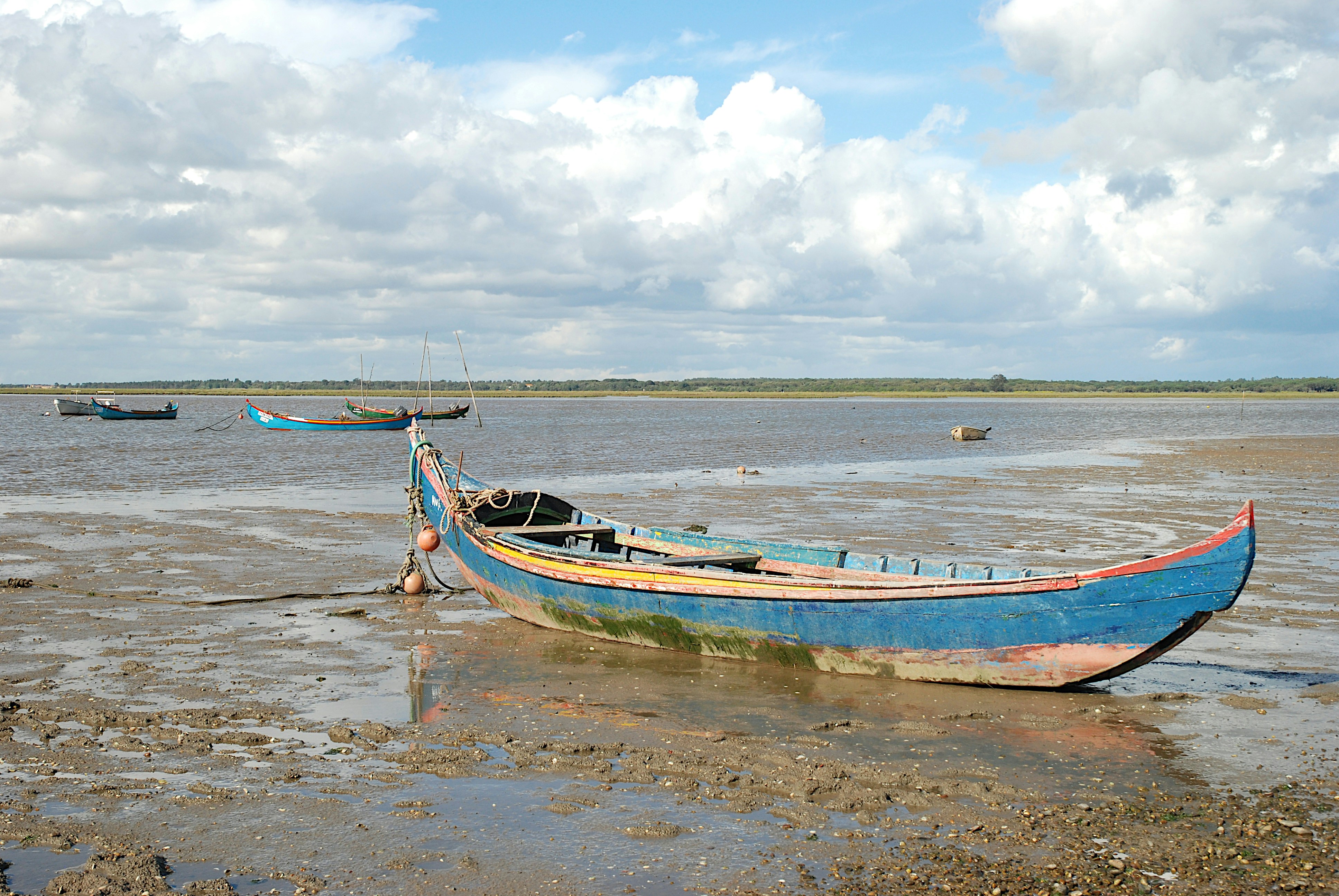 Old wooden boat resting on a muddy shore