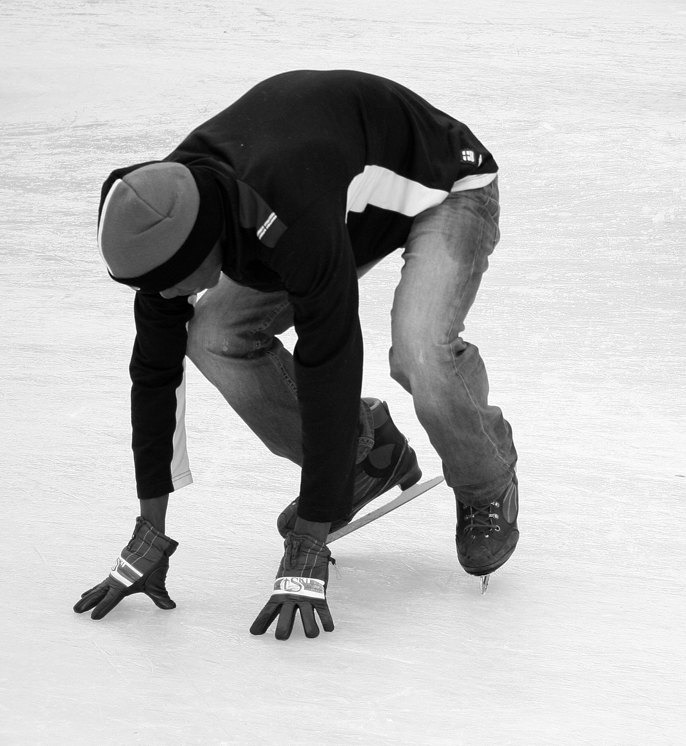 A person in a crouched position on ice skates.