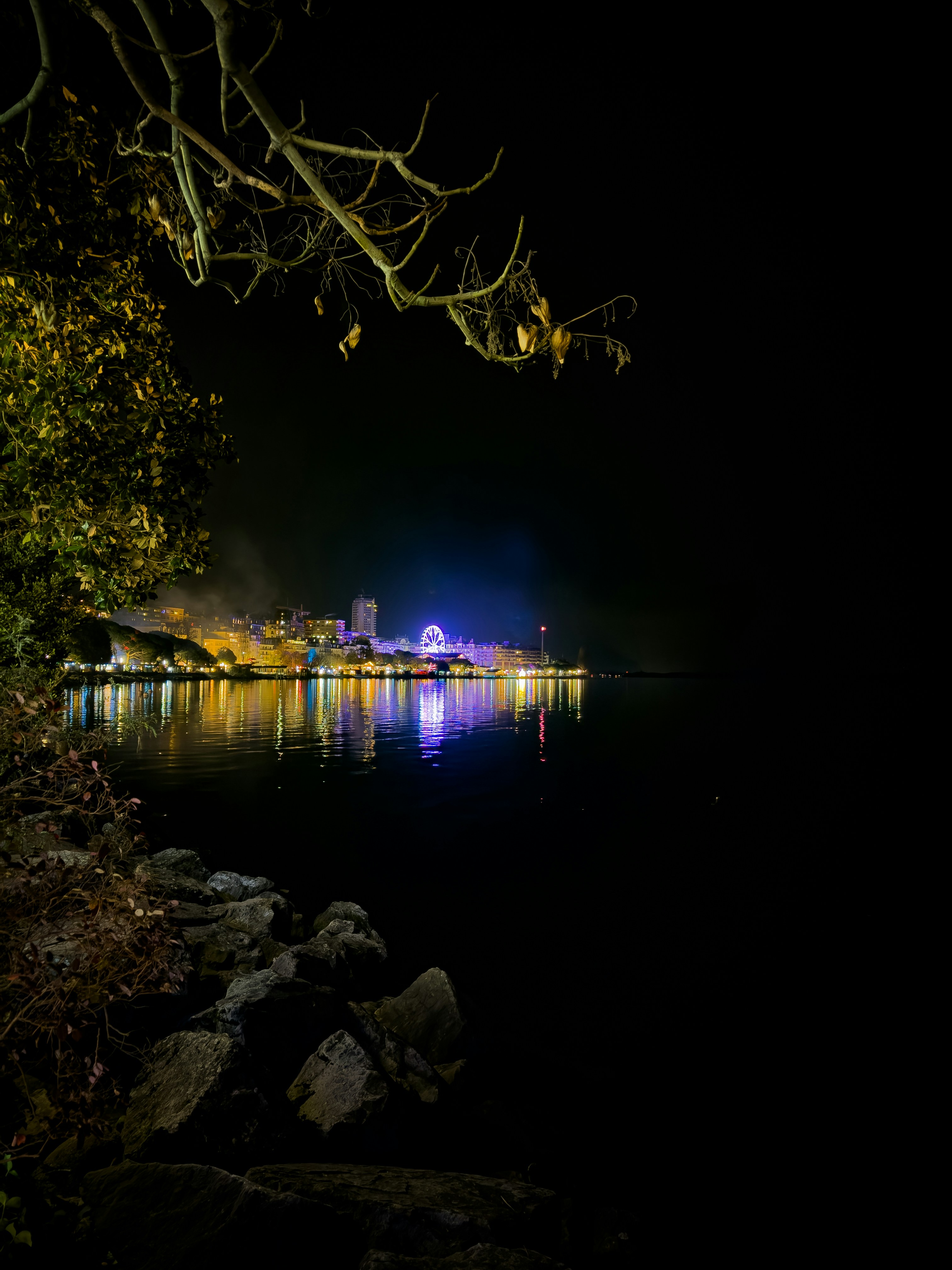 City lights reflecting on the water at night.