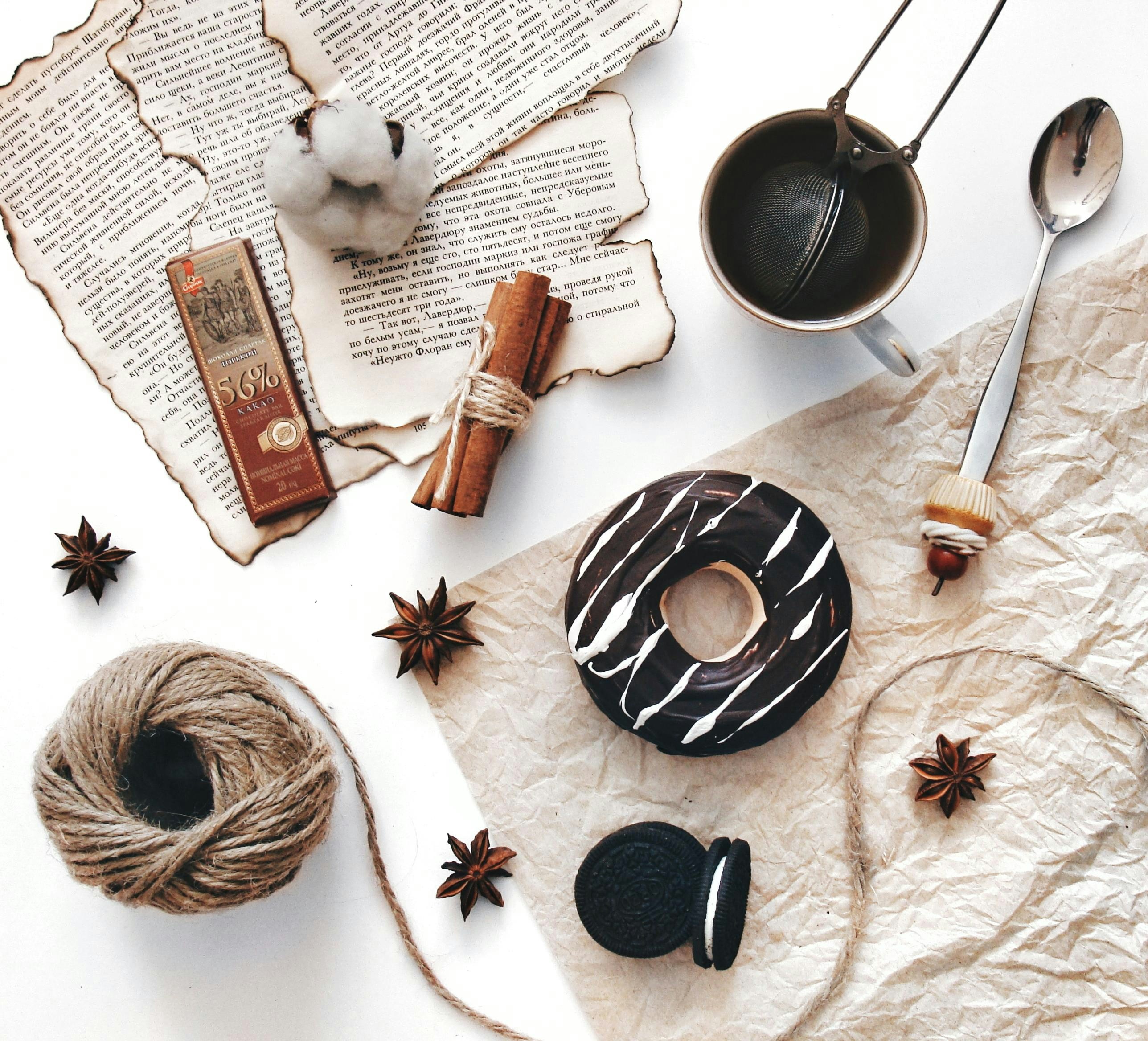 Donut, coffee, cinnamon sticks, and cotton on table