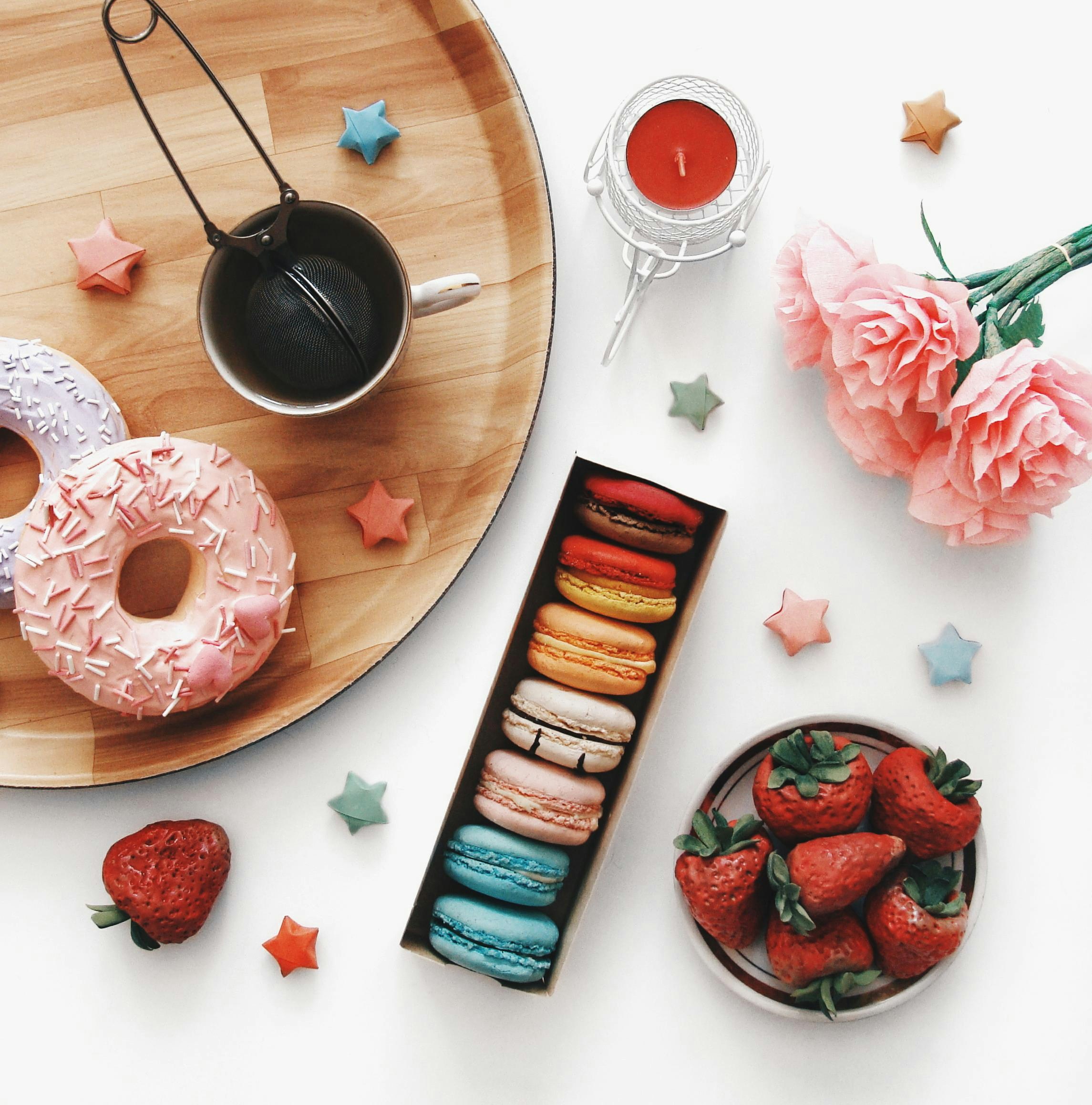 Sweet treats including donuts, macarons, and strawberries.