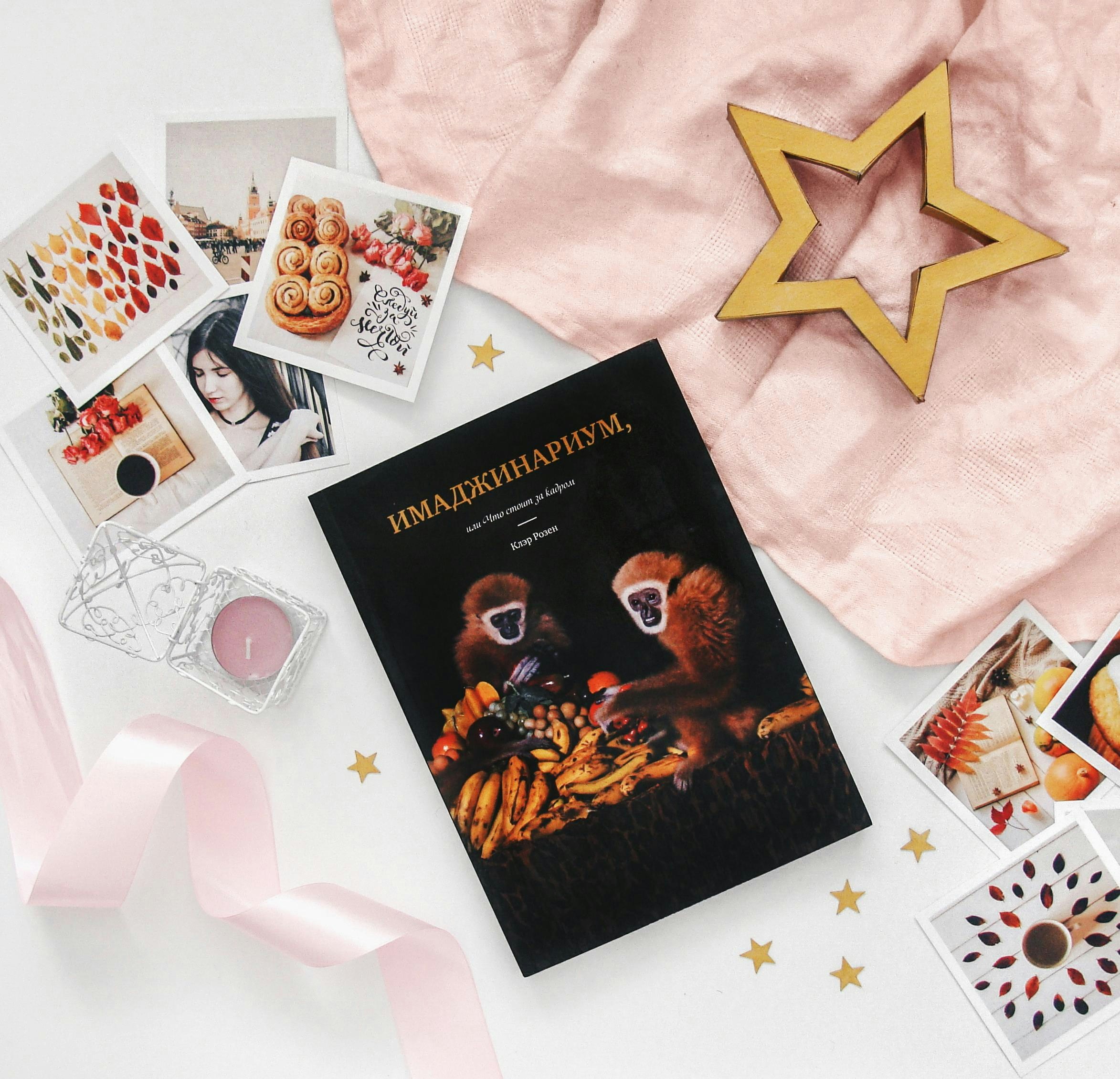 Book with monkeys, photos, and star decoration on pink fabric.