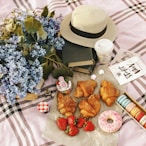 Picnic spread with pastries, strawberries, and flowers