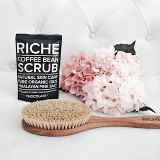 Coffee bean scrub with brush and flowers
