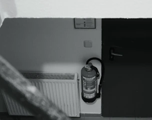 Fire extinguisher mounted on wall next to radiator.