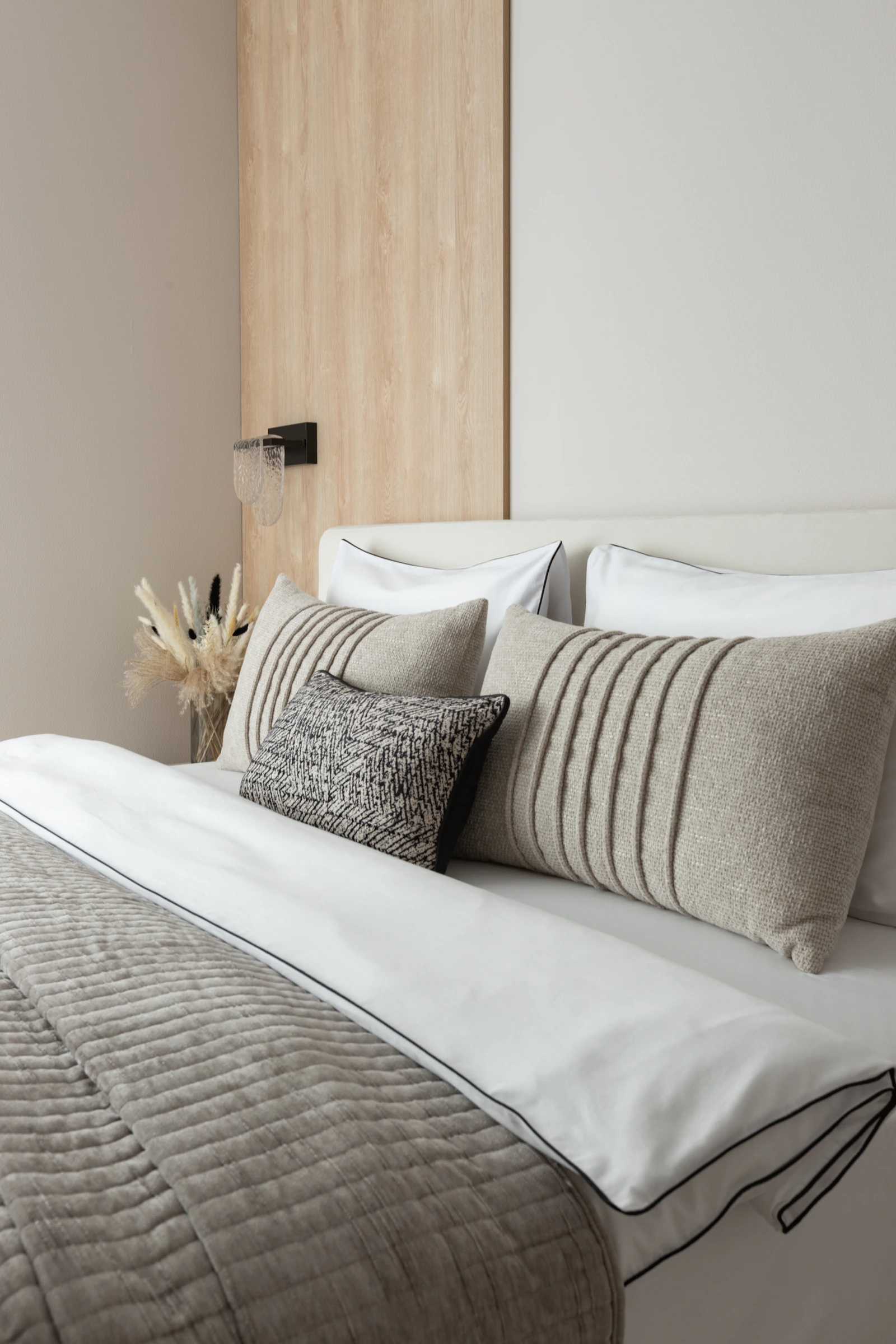 Neutral bedroom with layered pillows and soft bedding