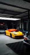 Yellow sports car covered with orange tarp in garage.