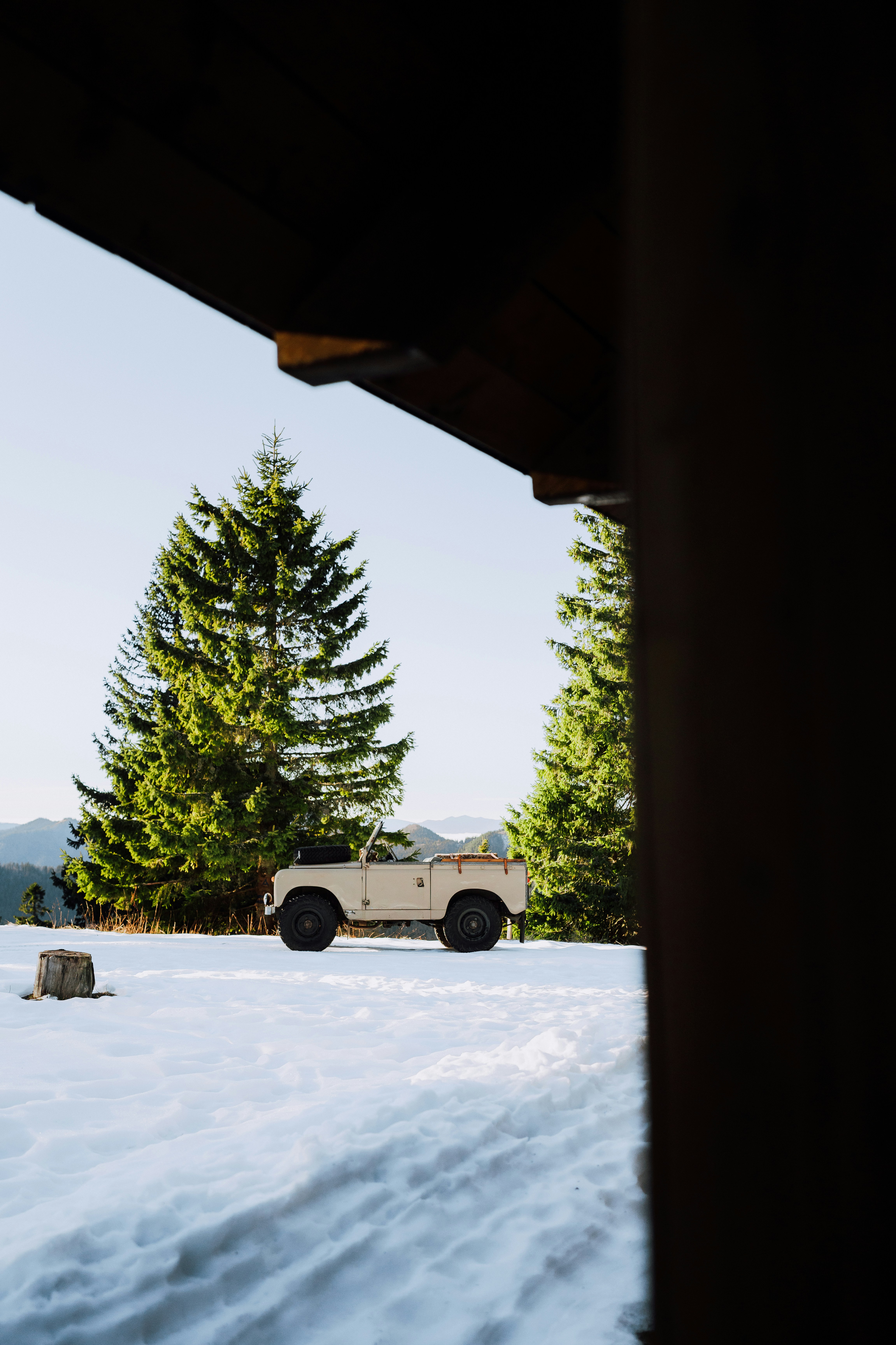 Vintage jeep parked in snowy mountain landscape