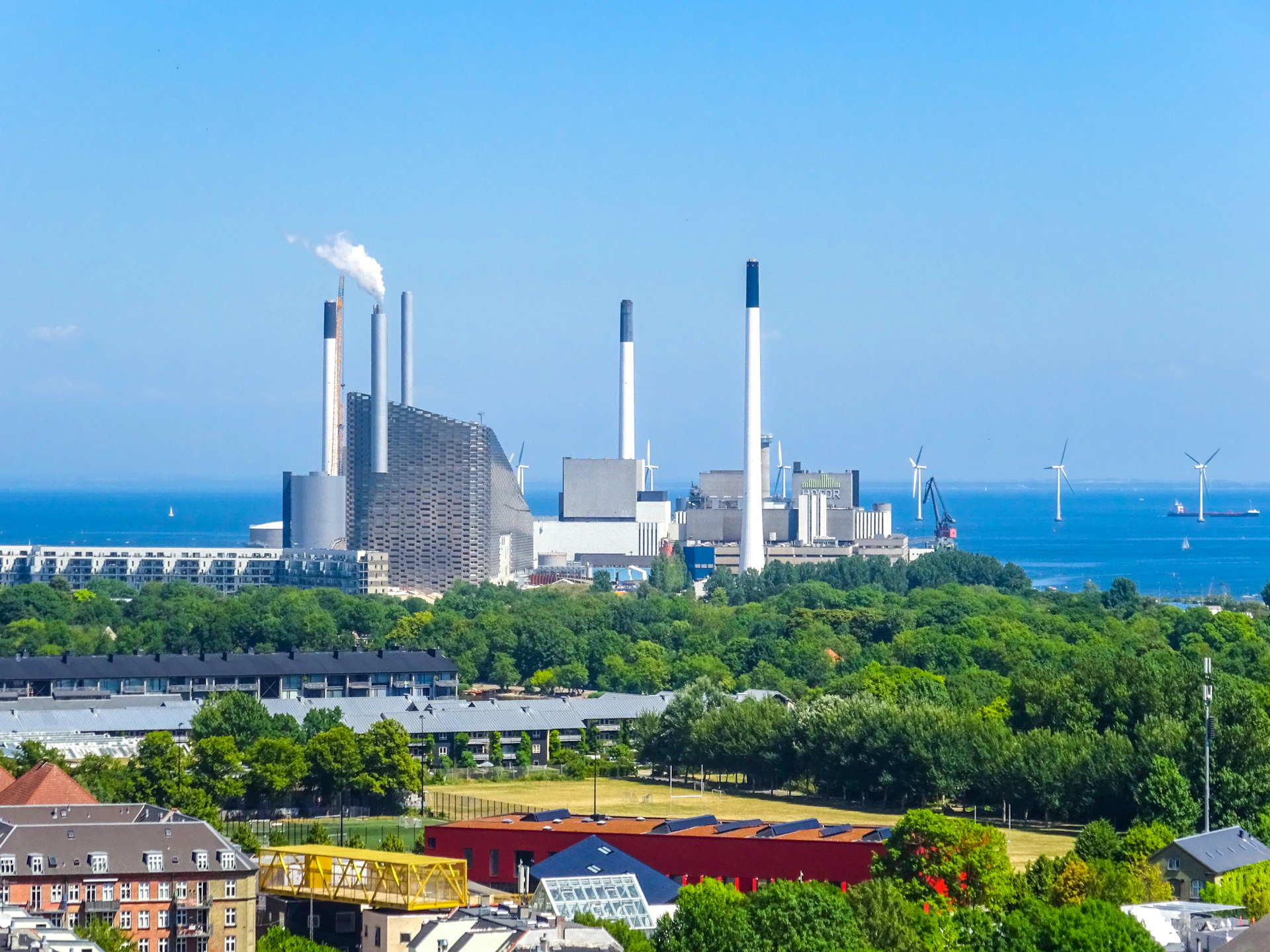 Industrial power plant with smokestacks by the ocean