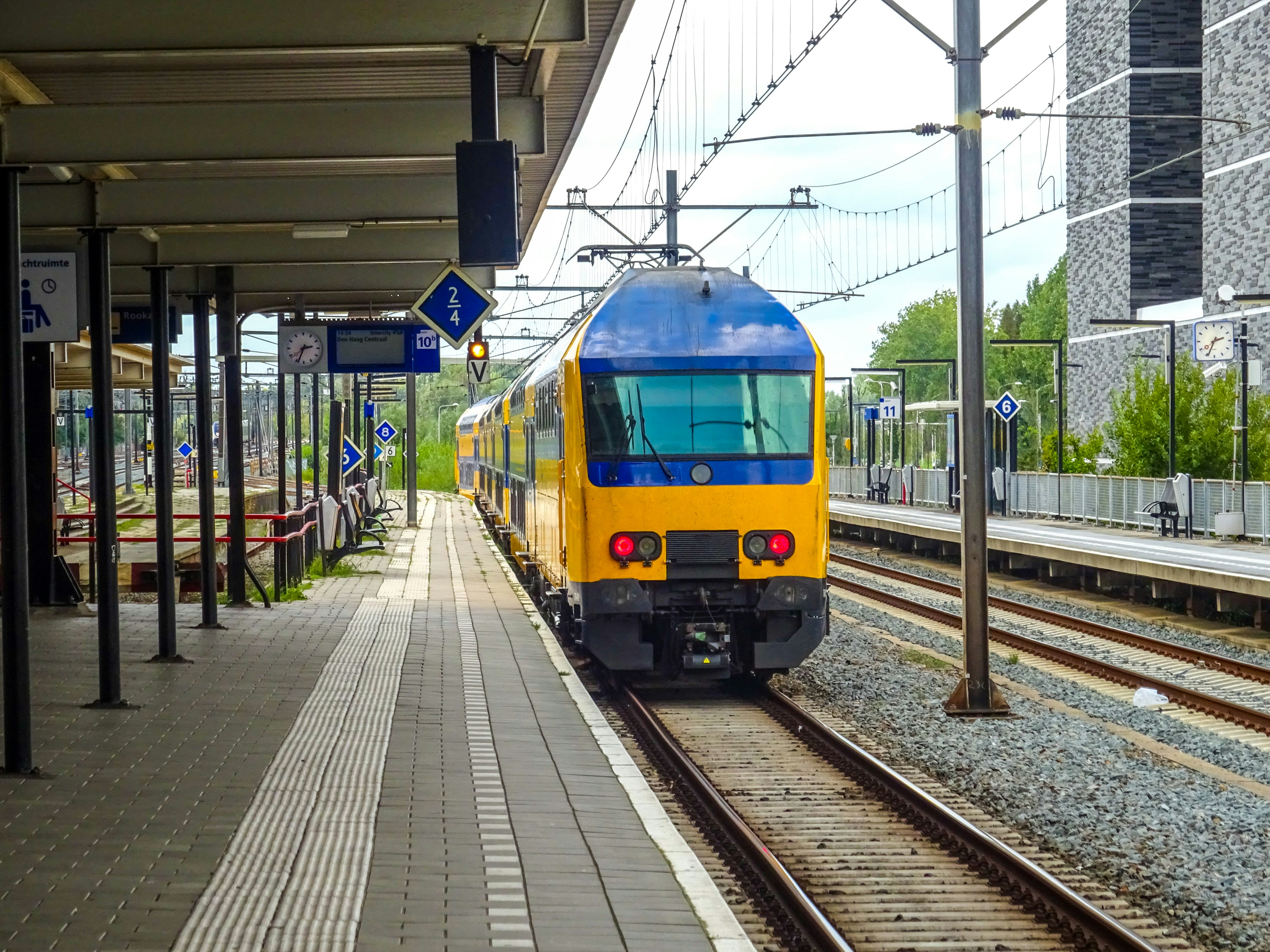 A yellow and blue train at a station platform.