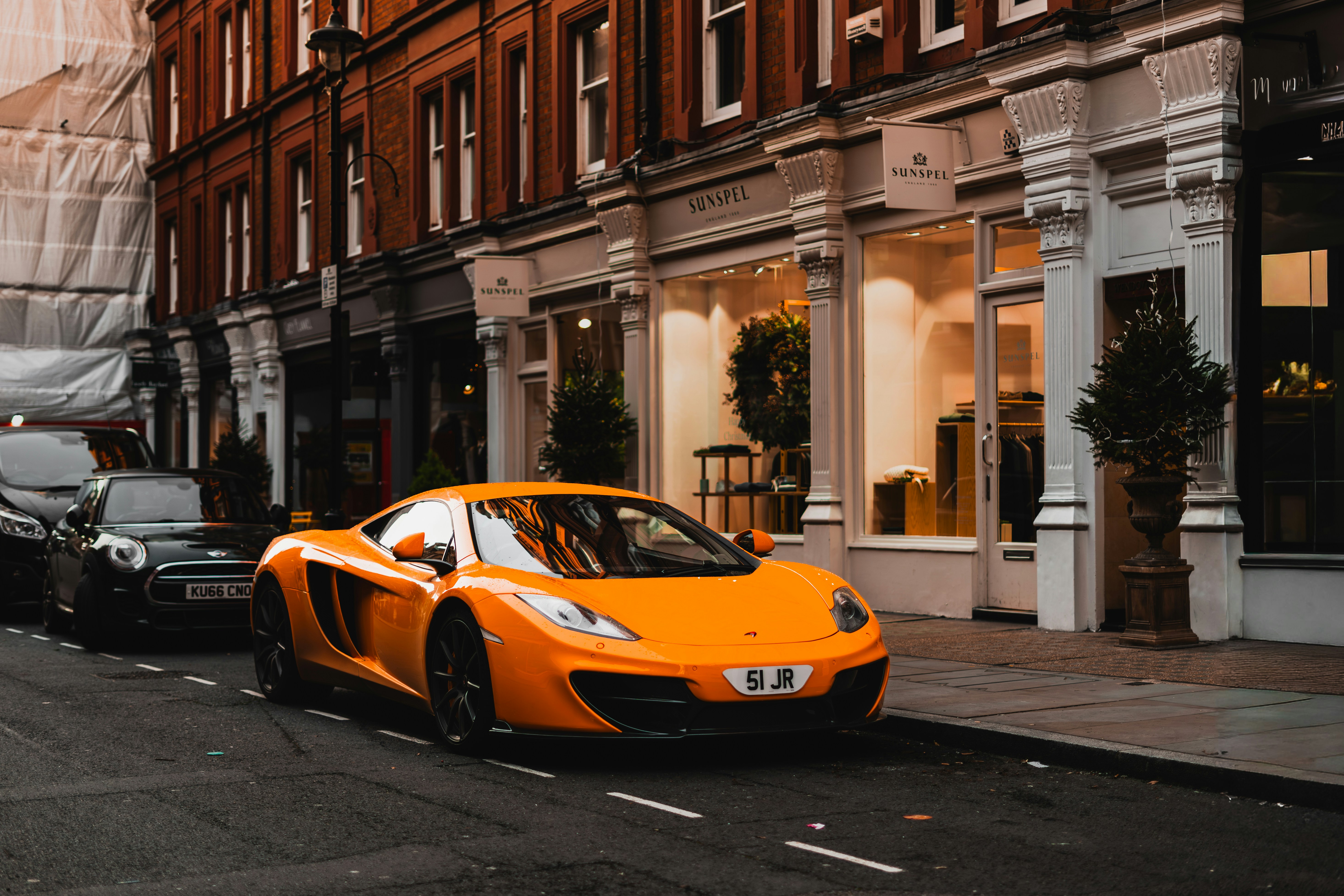 Orange sports car parked on a city street.