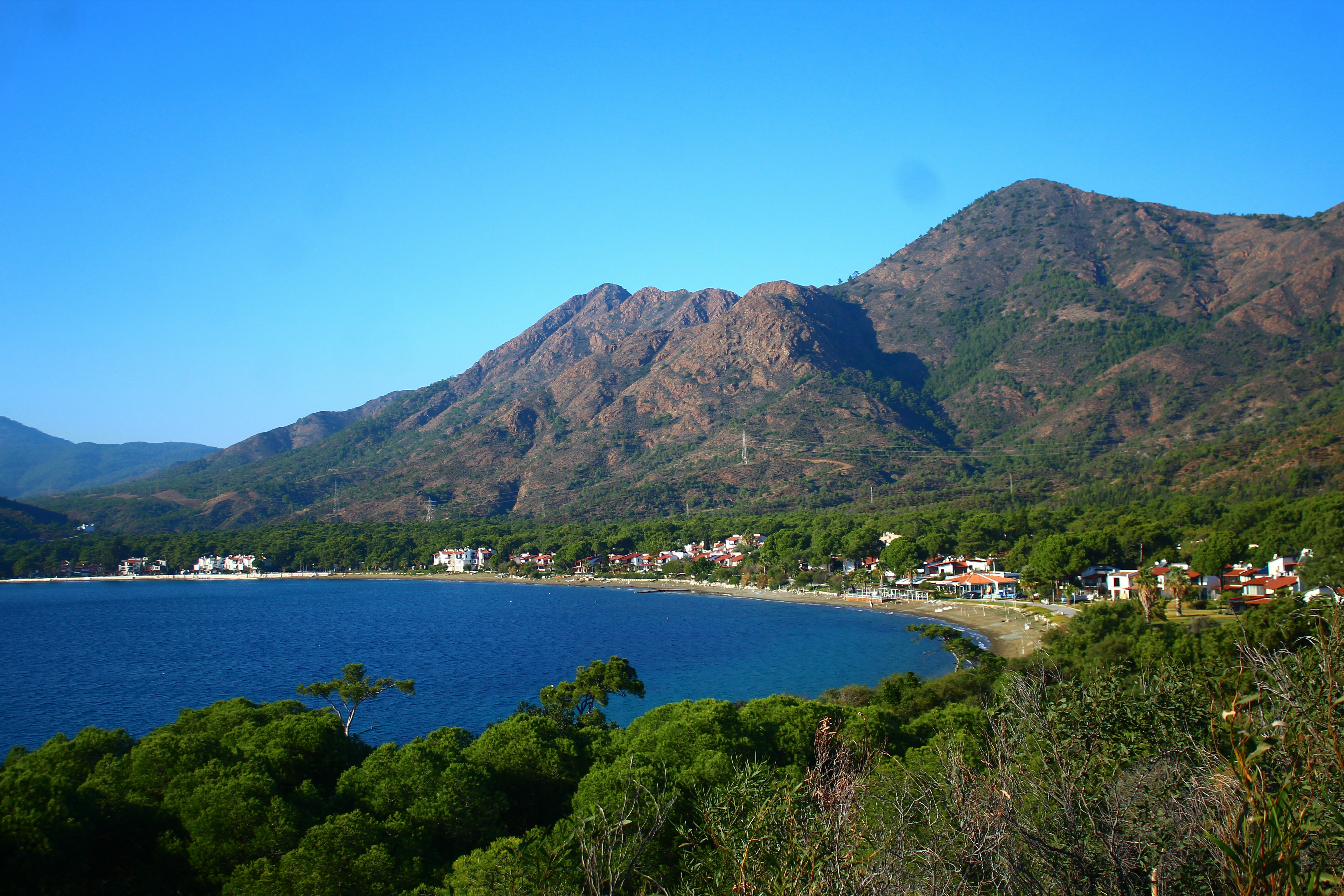 Coastal village nestled between mountains and blue sea.