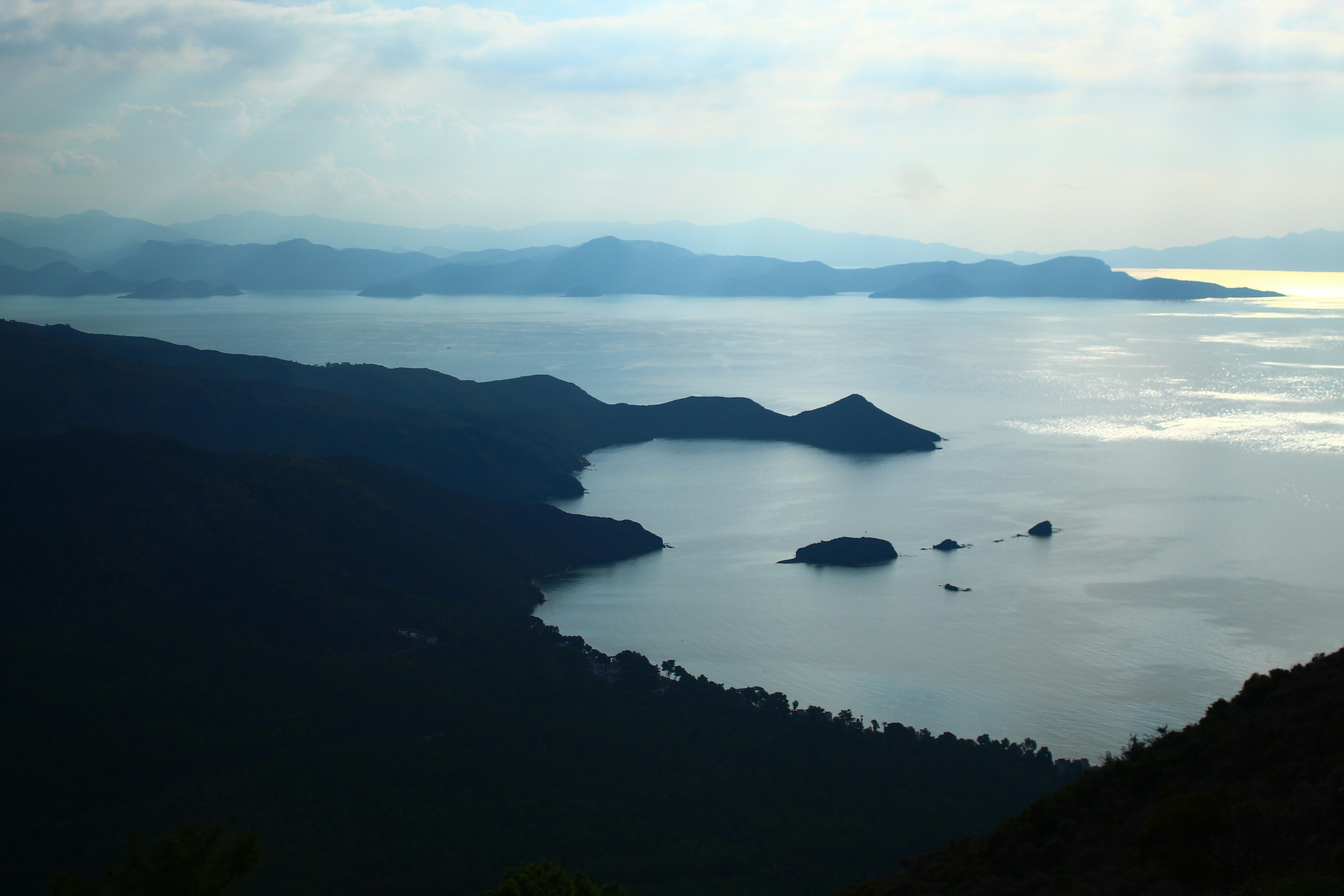 Calm ocean bay with distant islands and hills