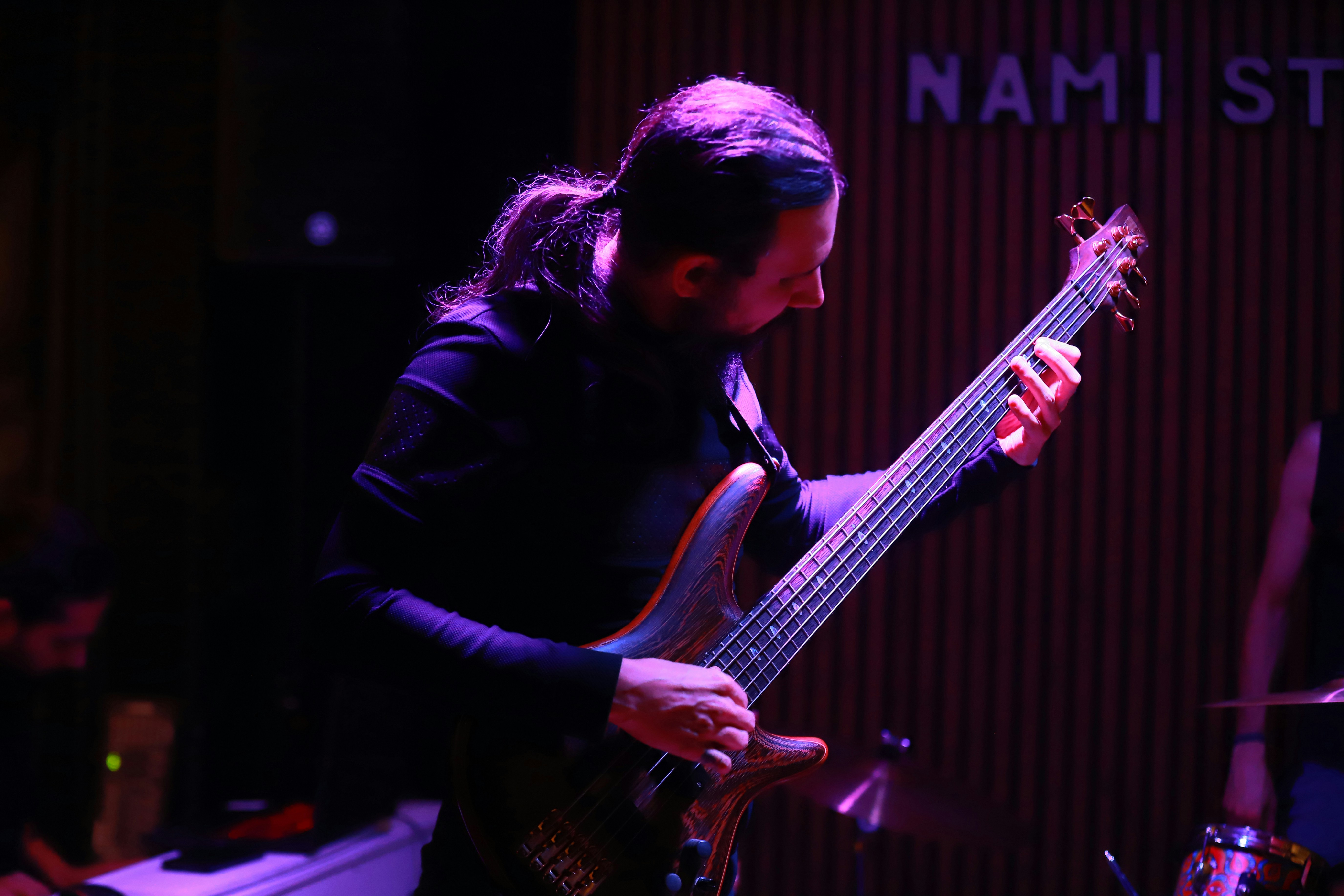 Man playing a bass guitar on stage
