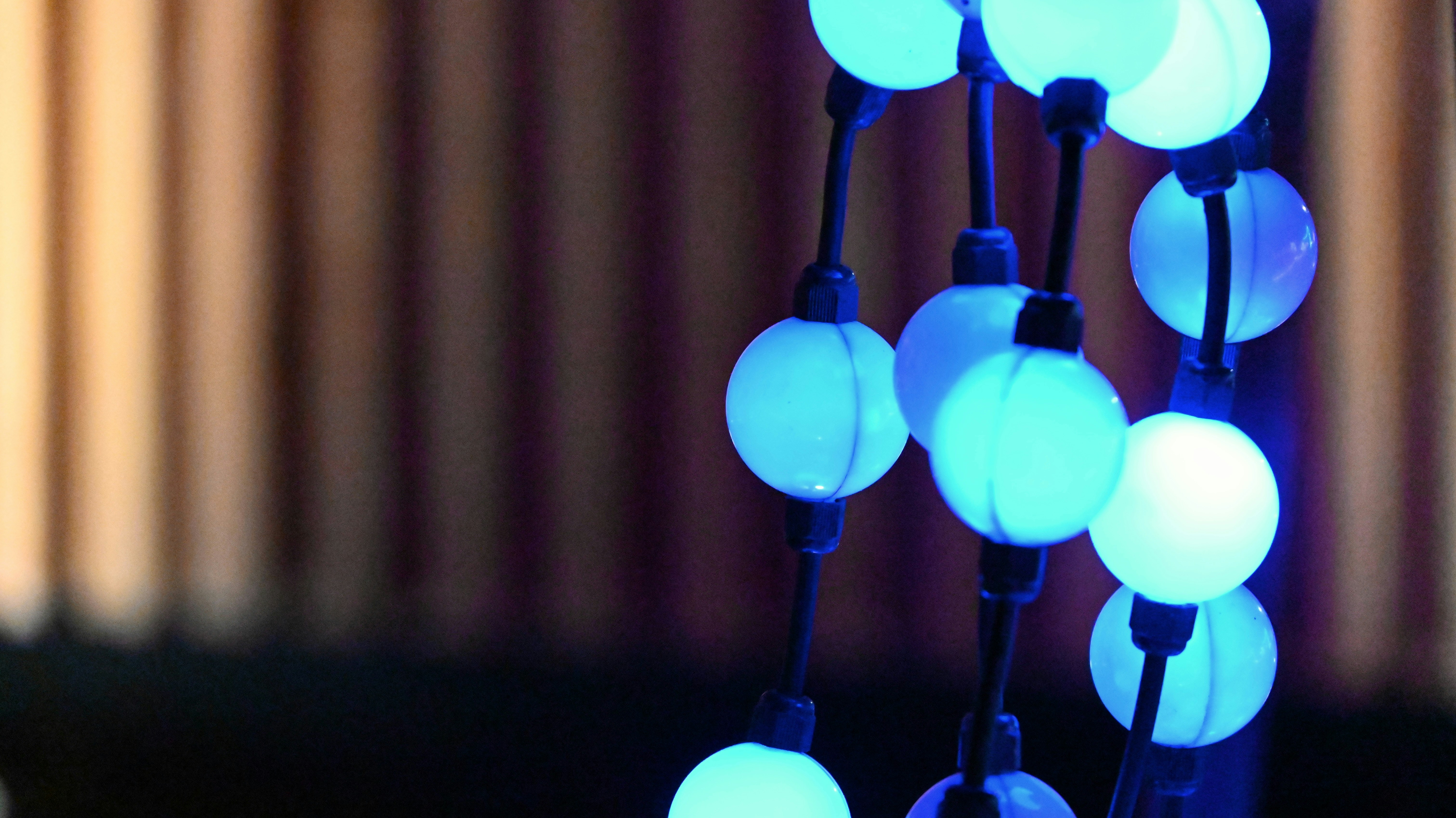 Close-up of glowing blue orb lights on a string.