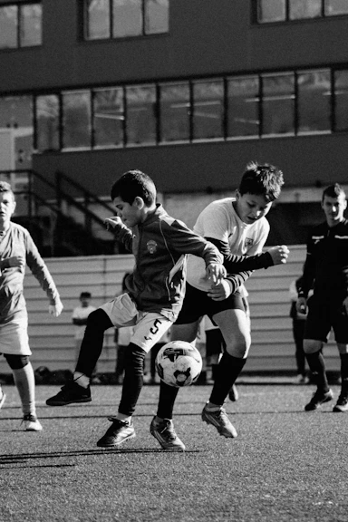 Two boys playing soccer on a field