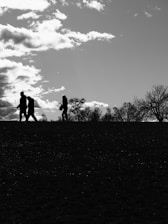 Silhouettes of people walking on a hill