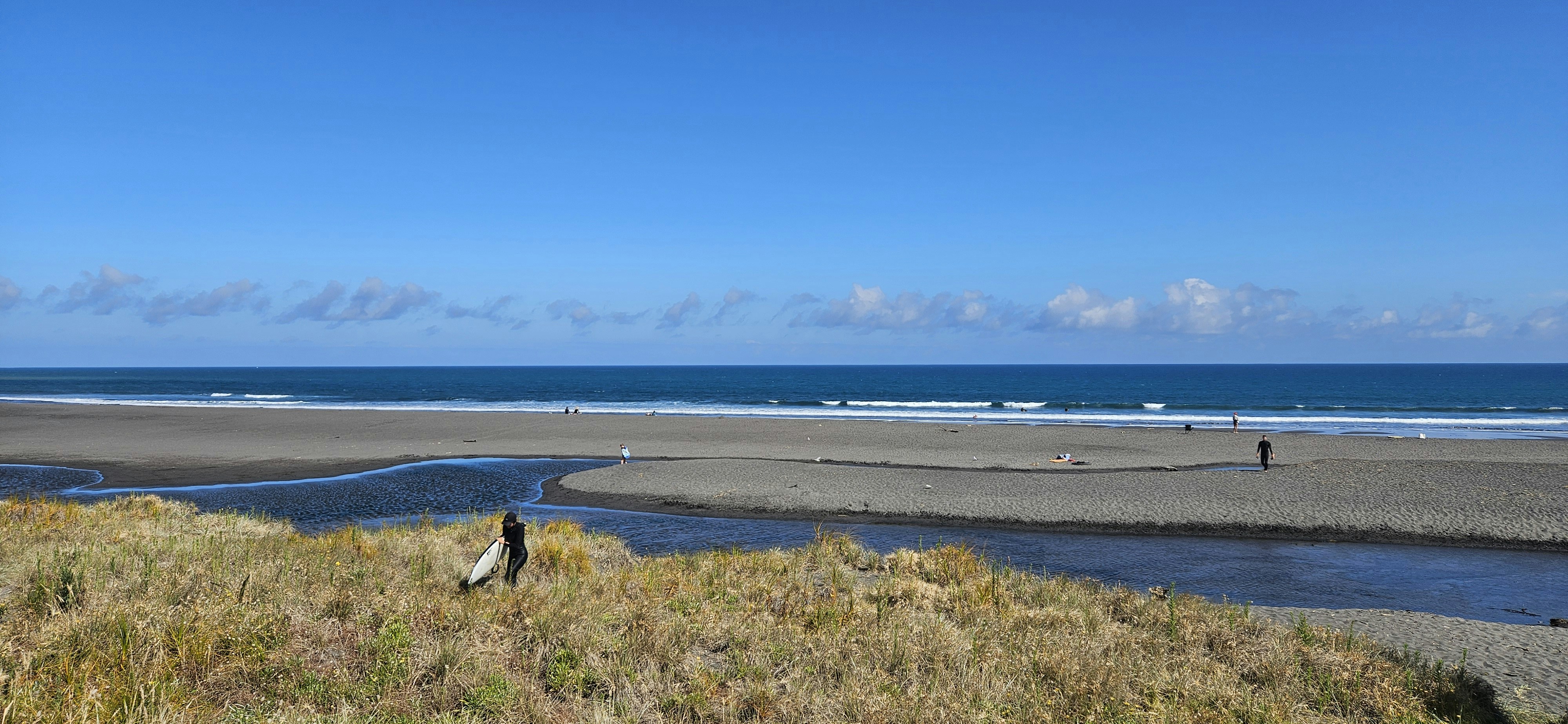A serene beach with a river meeting the ocean.