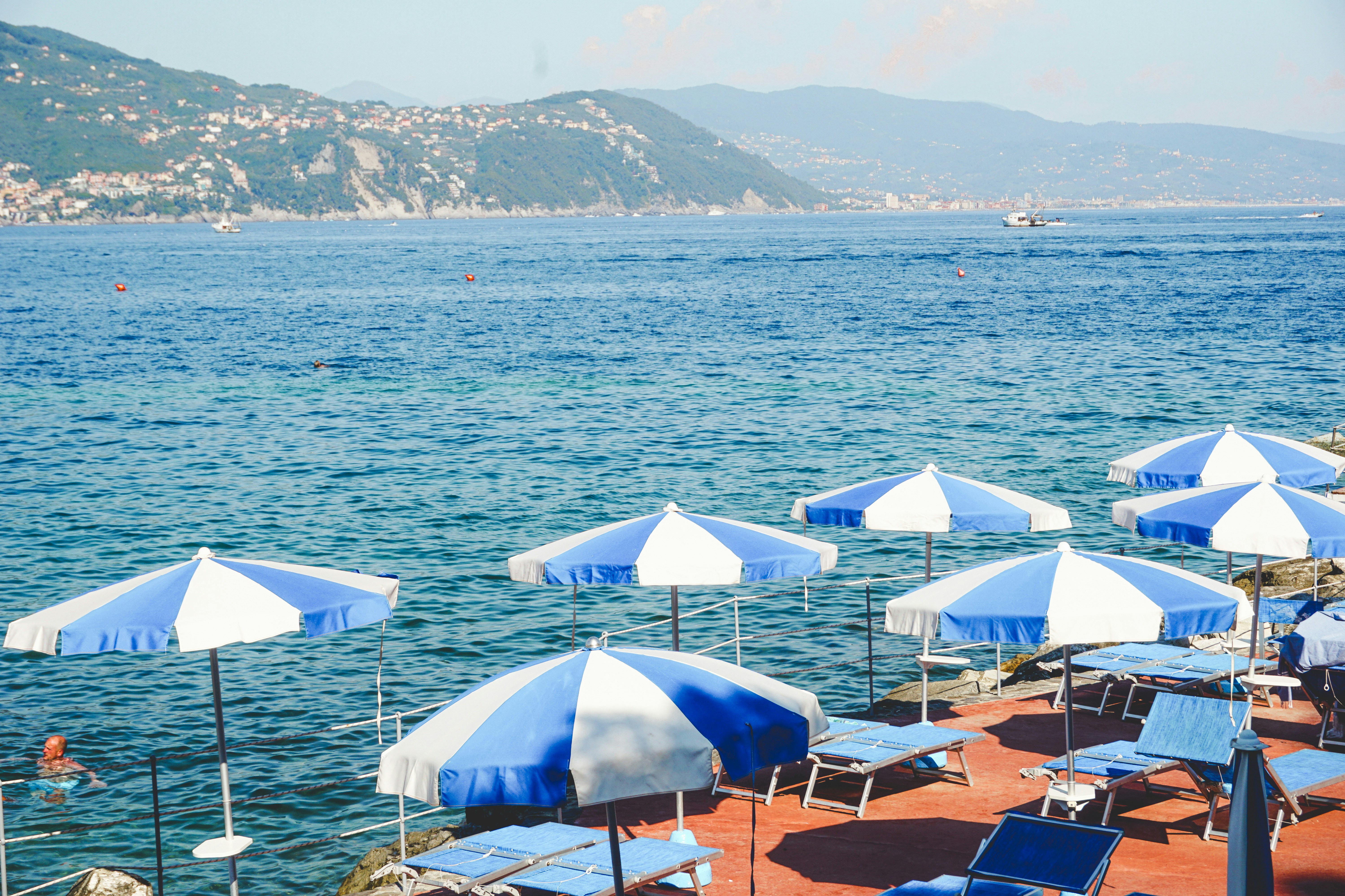 Beach umbrellas and lounge chairs by the blue ocean.