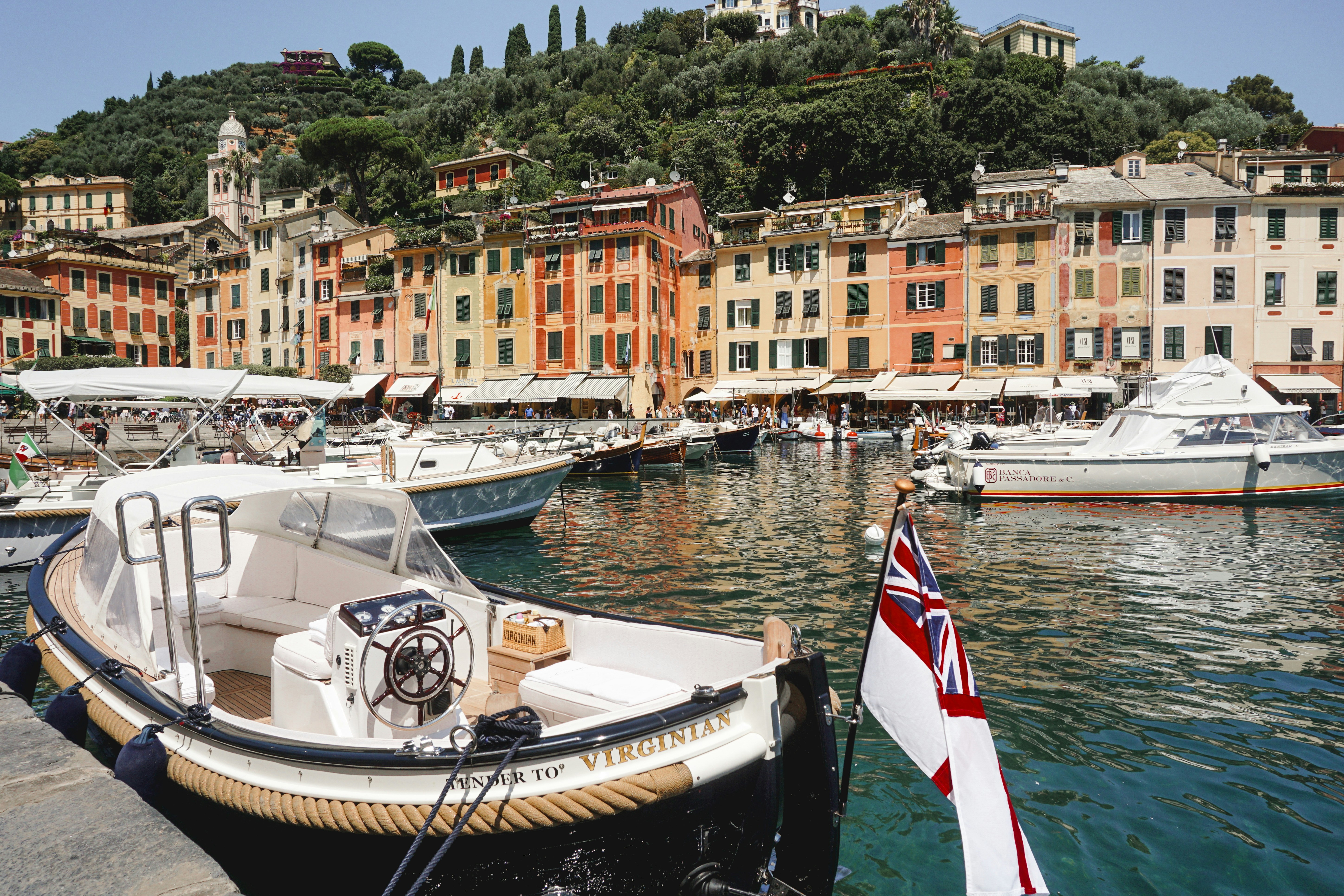 Colorful buildings line a harbor with boats and yachts.