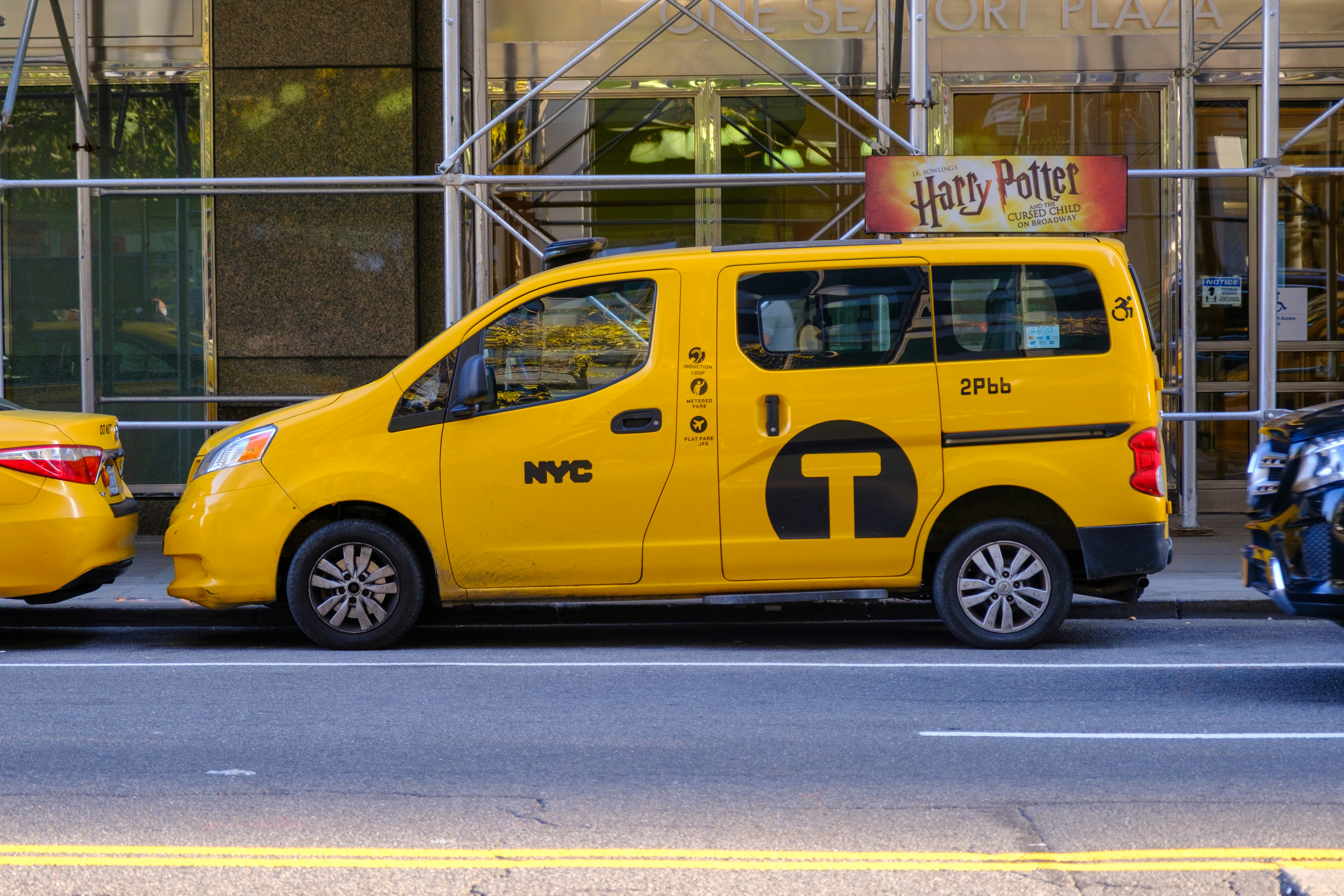 Yellow nyc taxi parked on city street