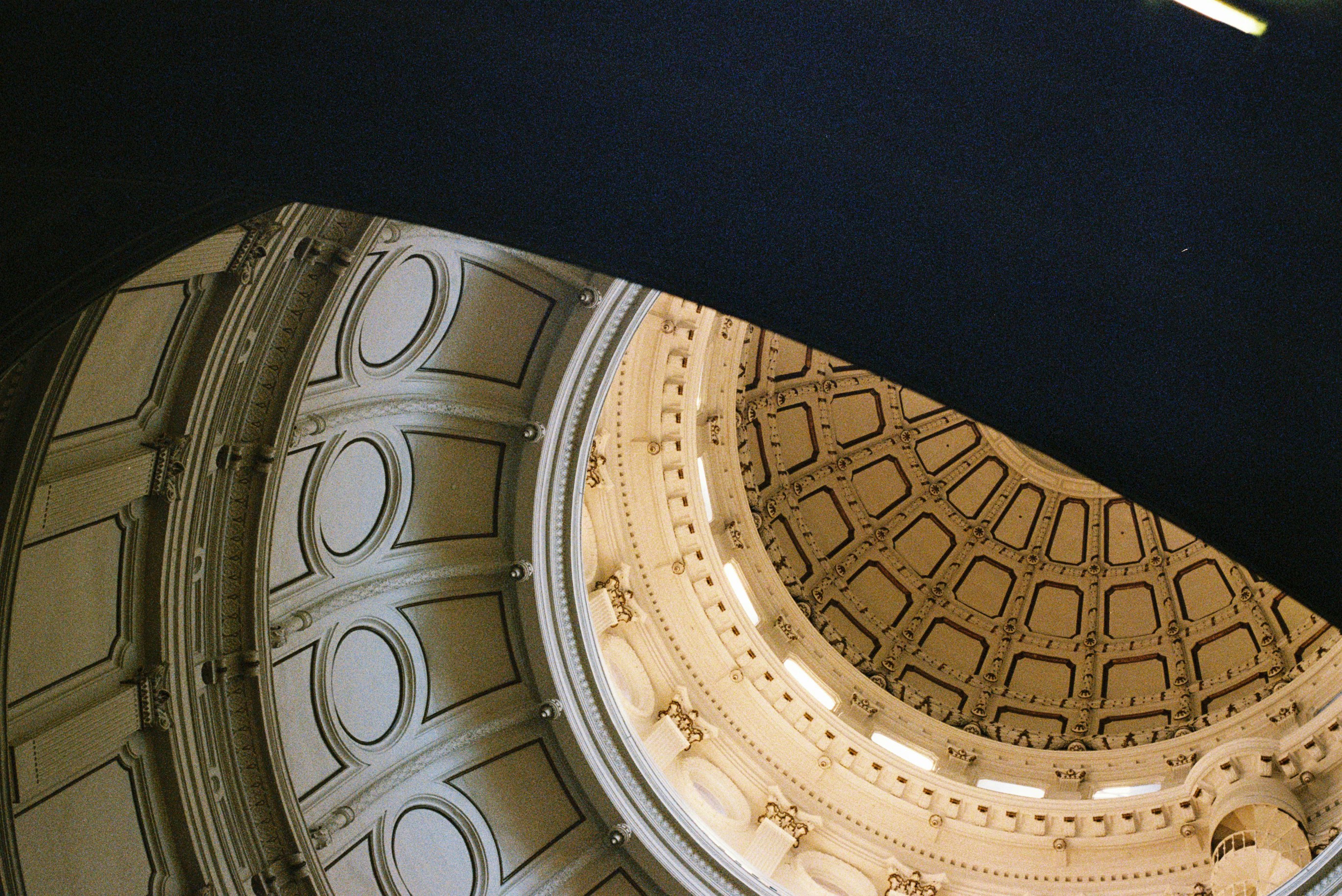 Looking up at a grand, ornate dome ceiling