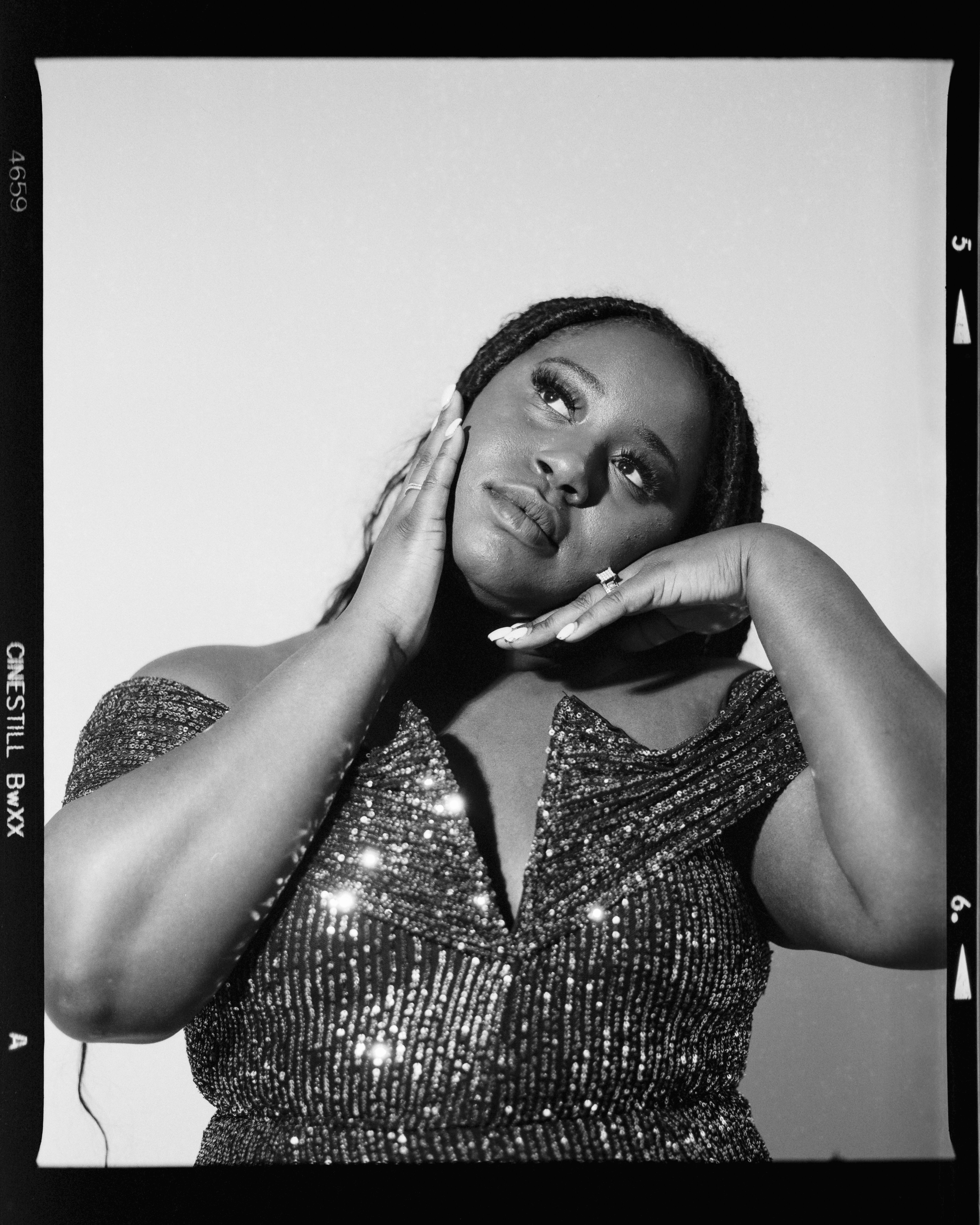 Une femme en robe scintillante pose avec réflexion