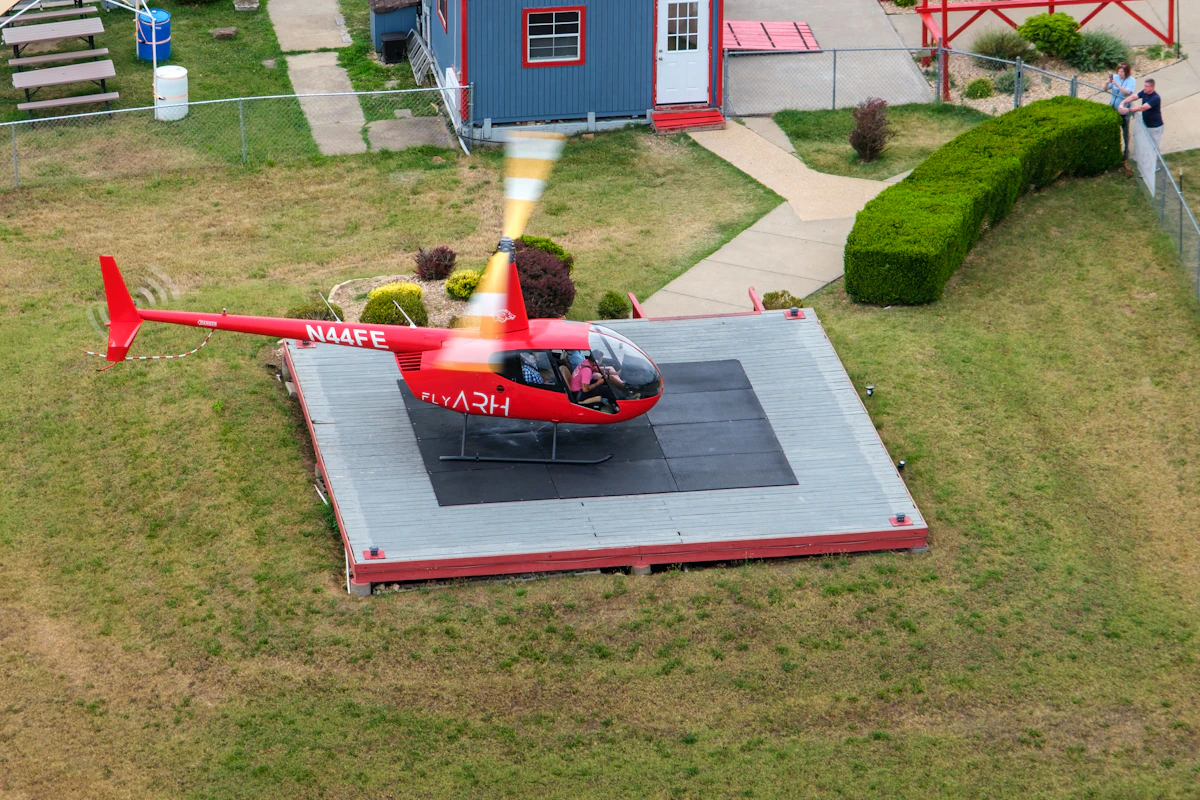A red helicopter on a private helipad seen from above, the door-to-door option in the helicopter vs private jet debate