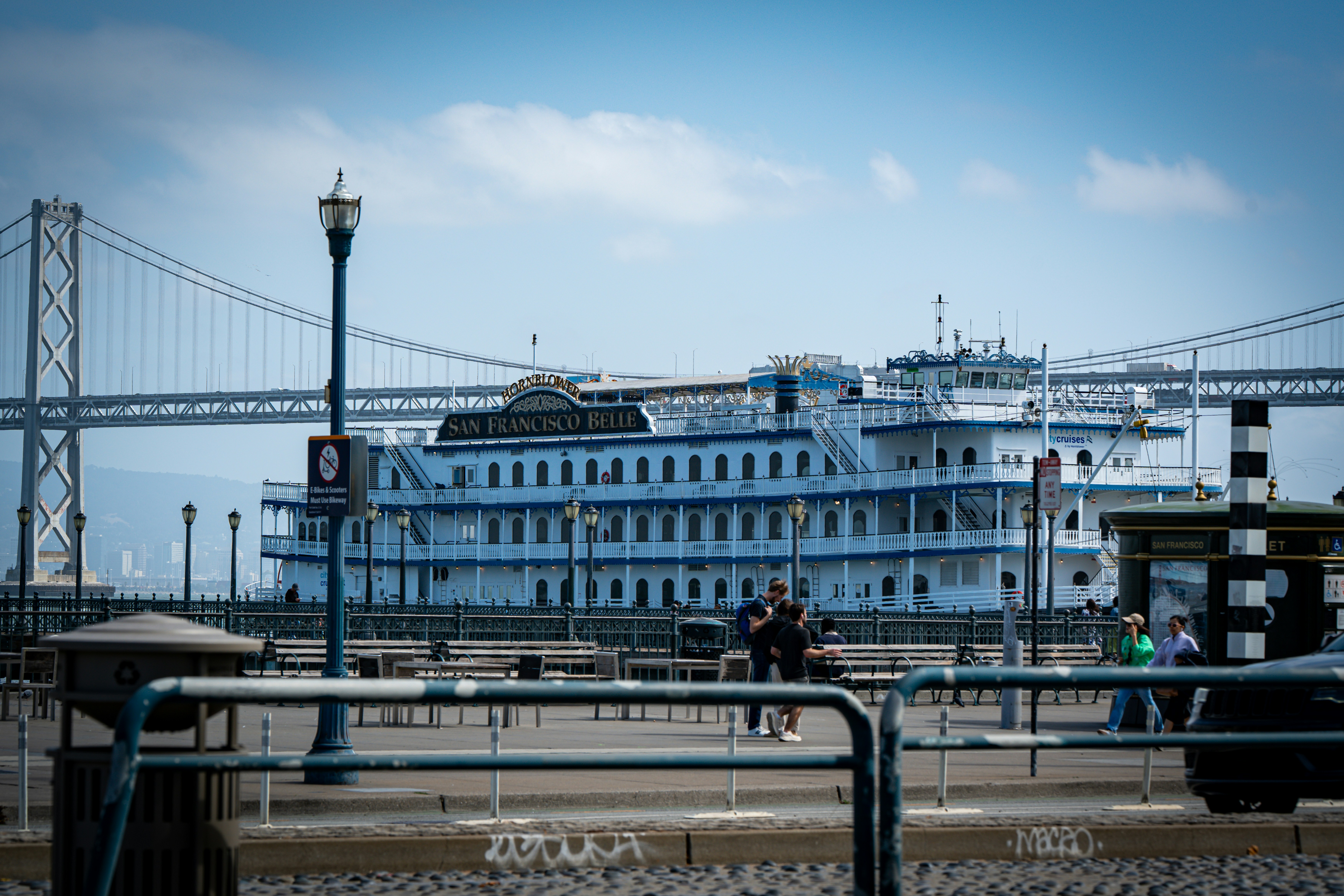 A large white boat docked near a bridge