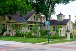 A charming yellow house with a porch and garden.