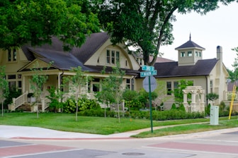 A charming yellow house with a porch and garden.