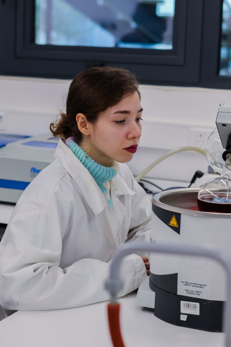 Young woman in lab coat working with equipment in a research laboratory