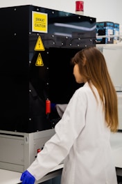 Scientist in lab coat works with equipment