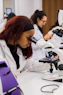 Young woman using a microscope in a science lab.