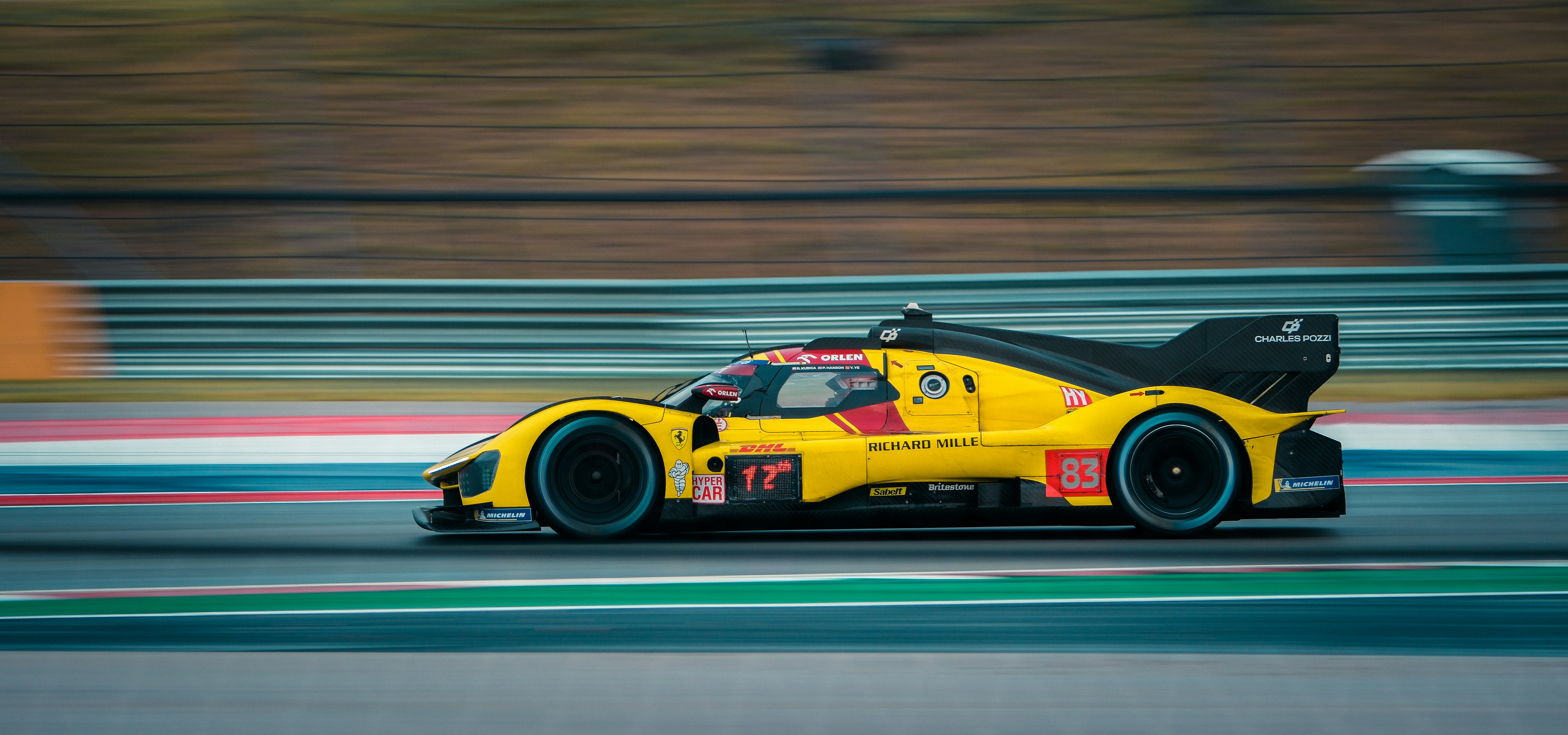 Yellow race car speeding down a track.