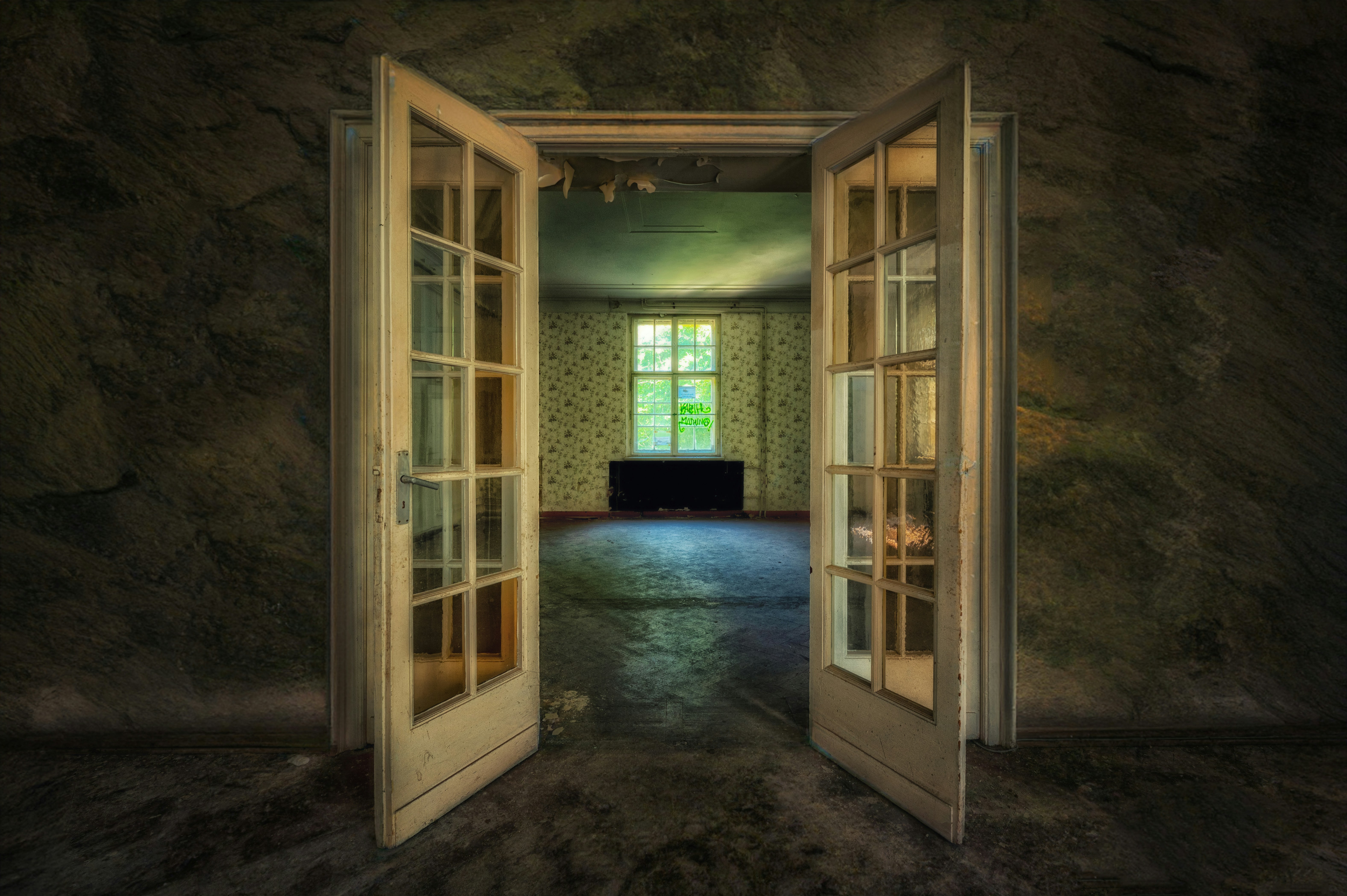 Open doors revealing an empty room with a window