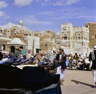 People gathered in a bustling marketplace with traditional buildings.