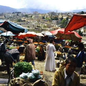 Bustling outdoor market with people and produce.