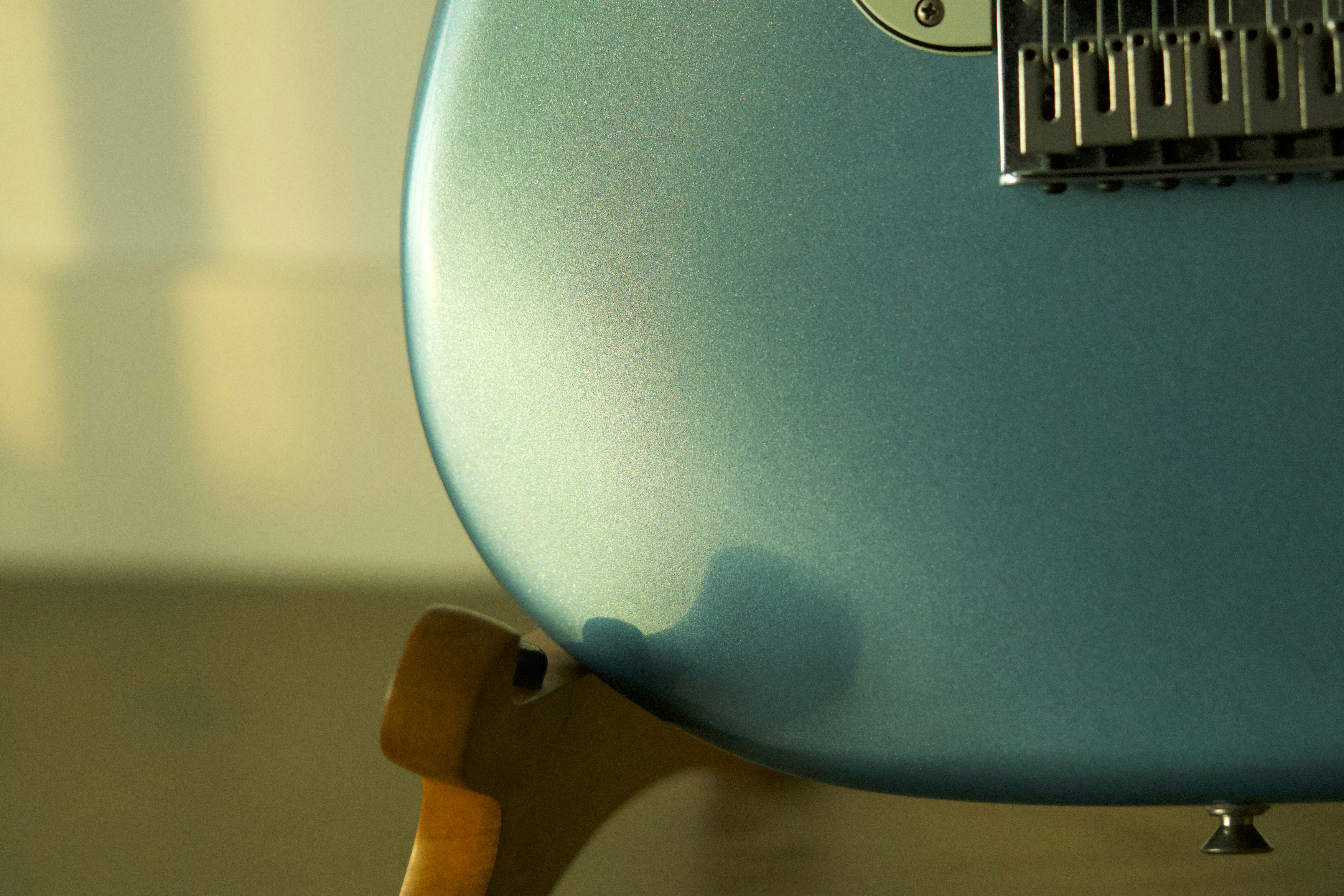 Close-up of a shiny blue electric guitar body.