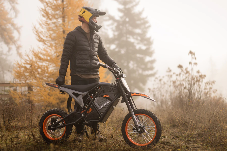 Rider standing with a custom electric dirt bike in the fog