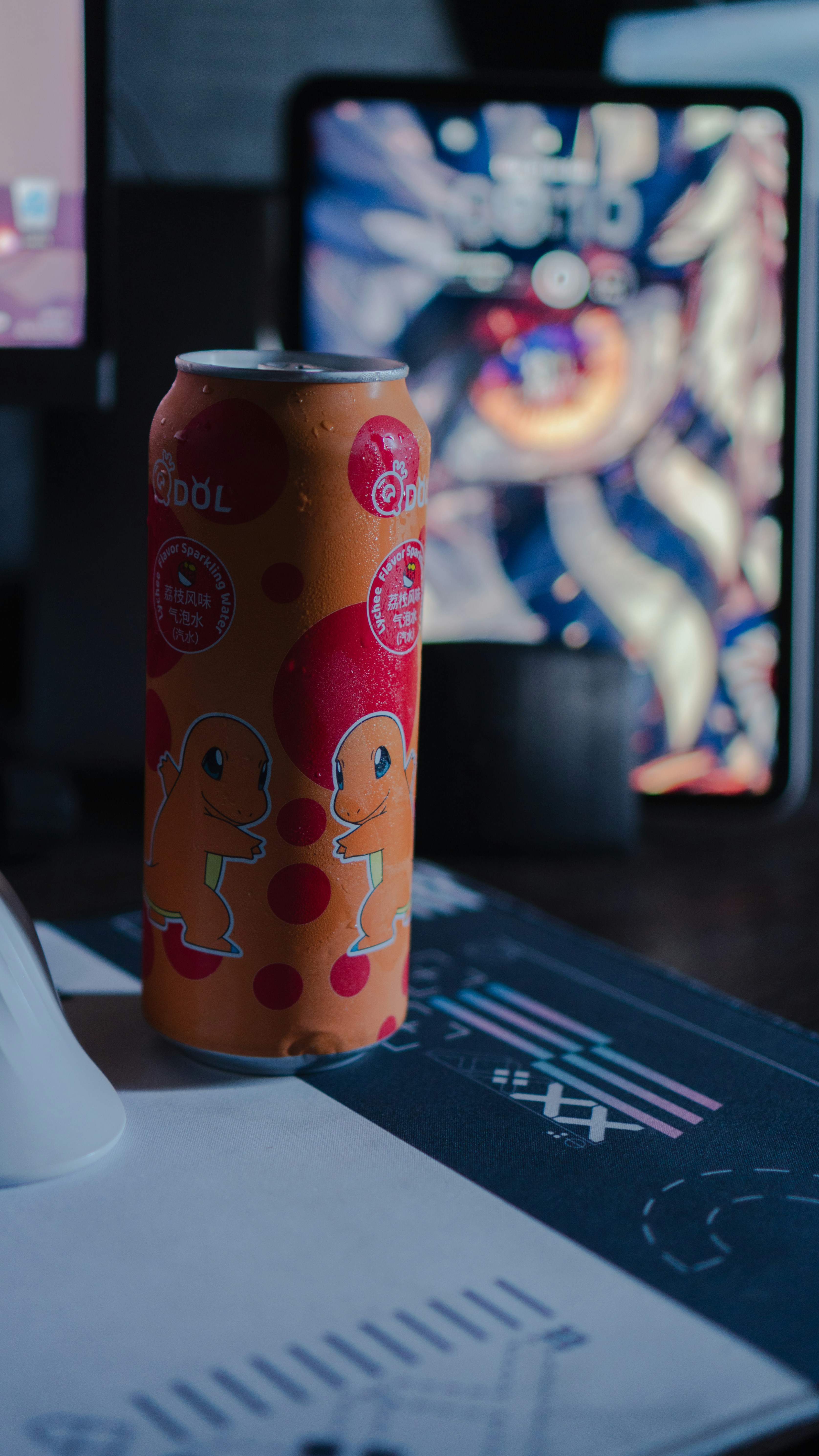 Lata de refresco naranja con diseño de charmander en el escritorio.