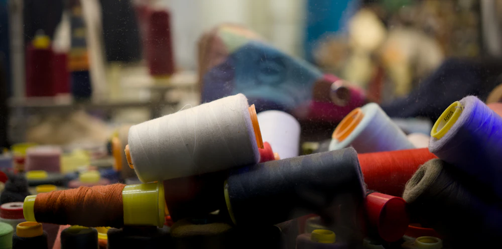 Spools of embroidery thread piled together in many colours