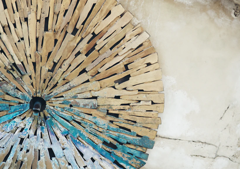 Circular stone mosaic with blue accents on wall