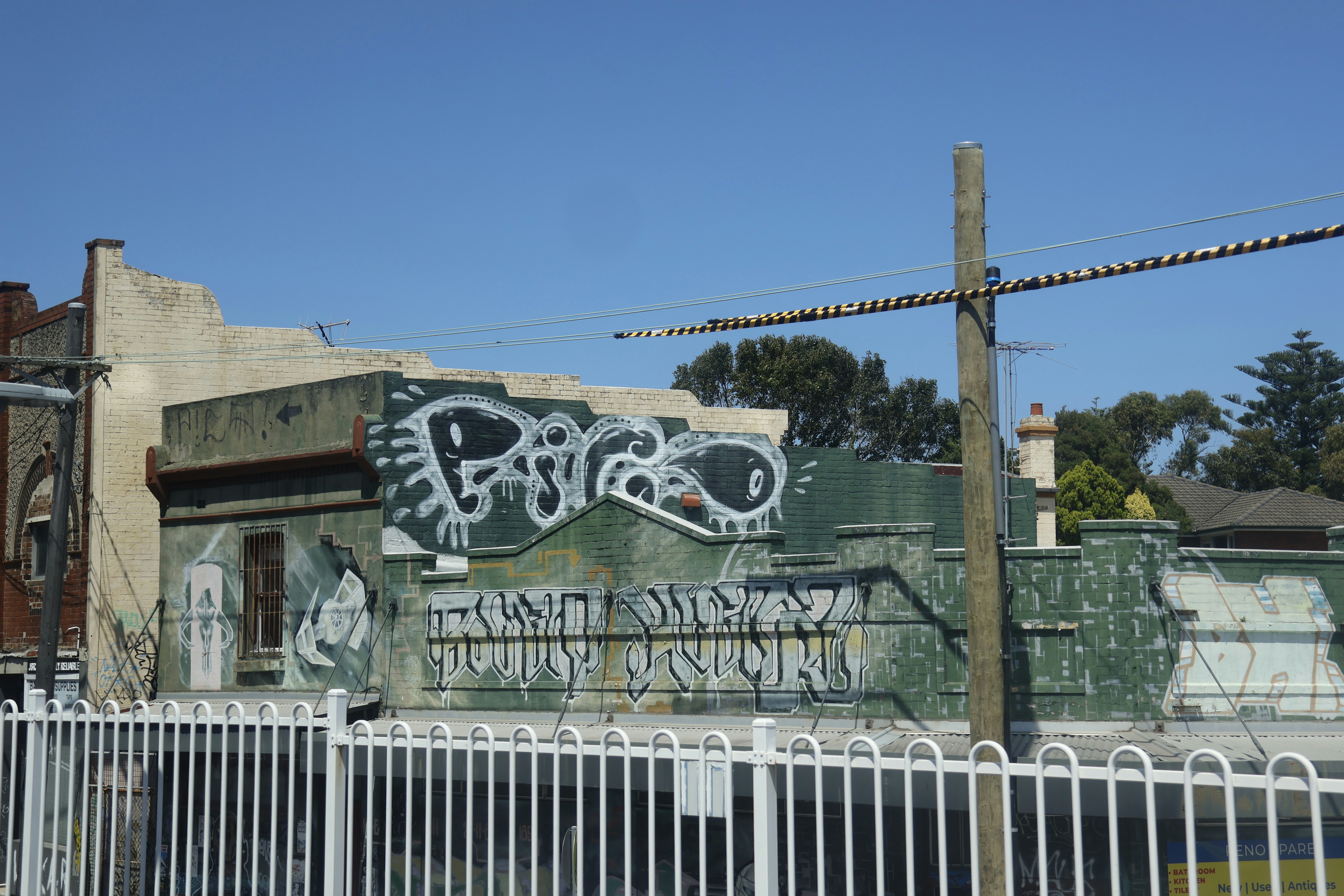 Graffiti on a weathered building wall under blue sky