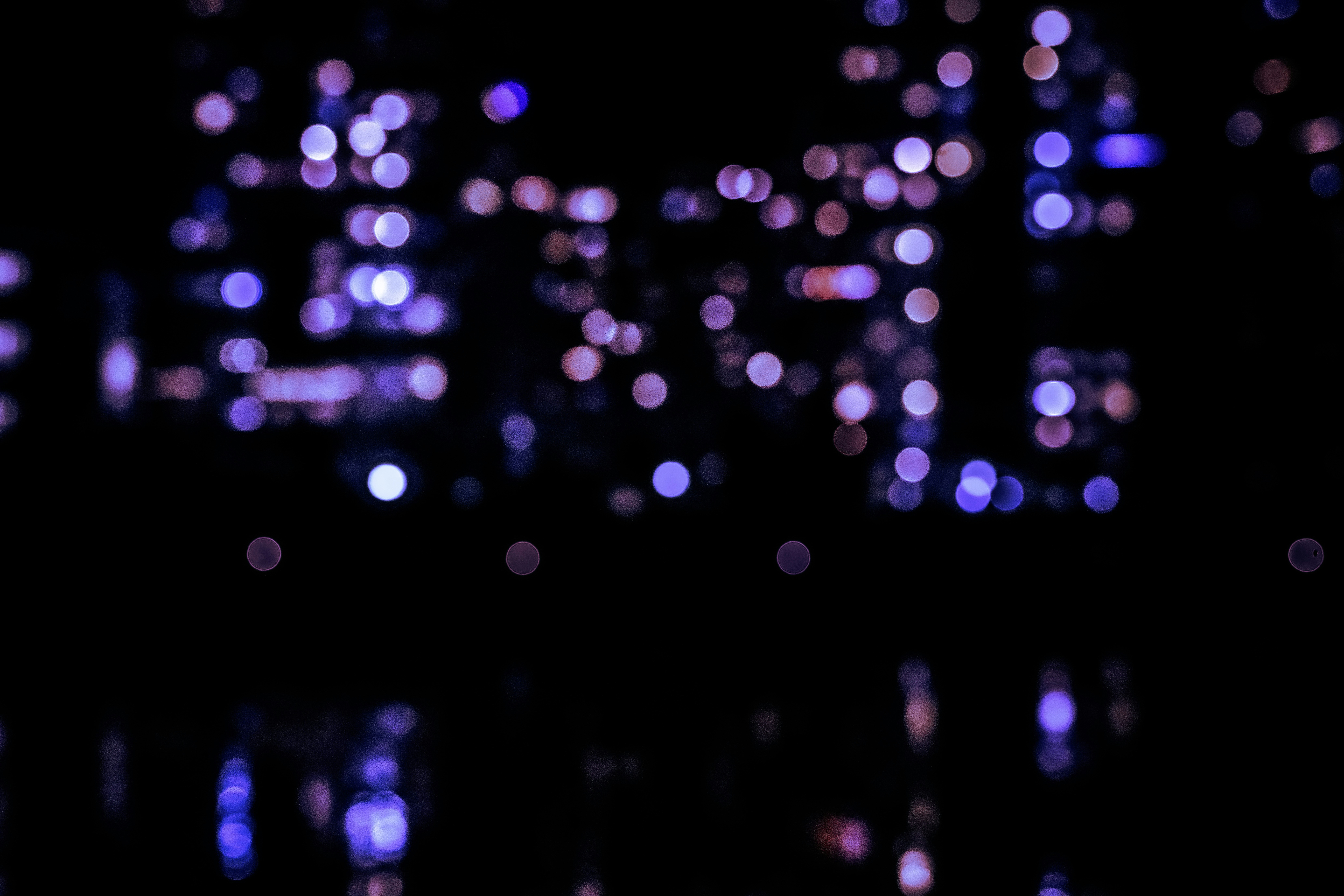 Blurred purple and pink bokeh lights at night.