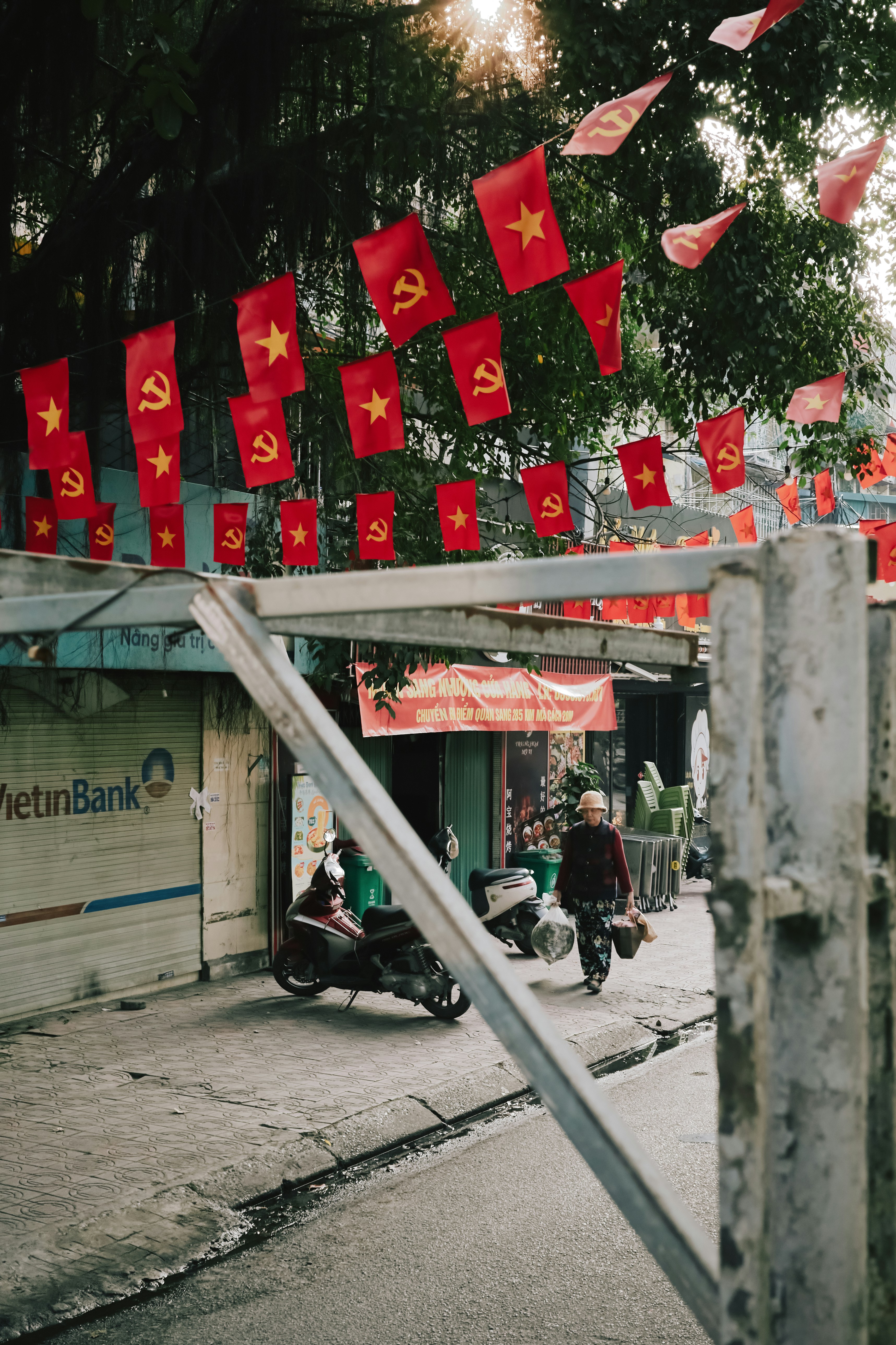 Red flags with stars and hammers hang above street.