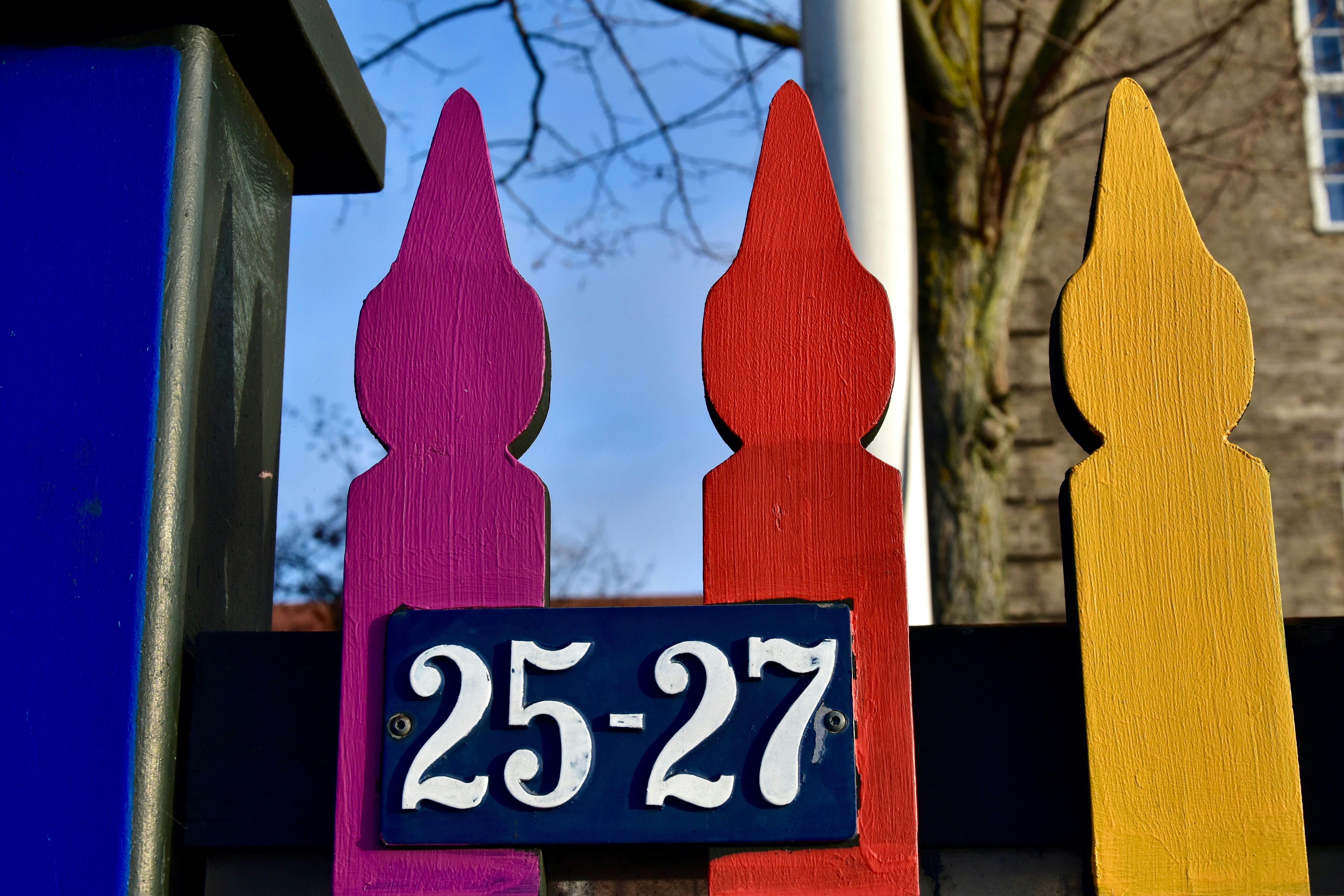 Colorful fence with house numbers 25-27