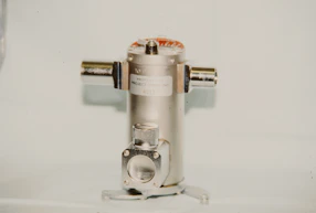 A metallic cylindrical object with two side connectors
